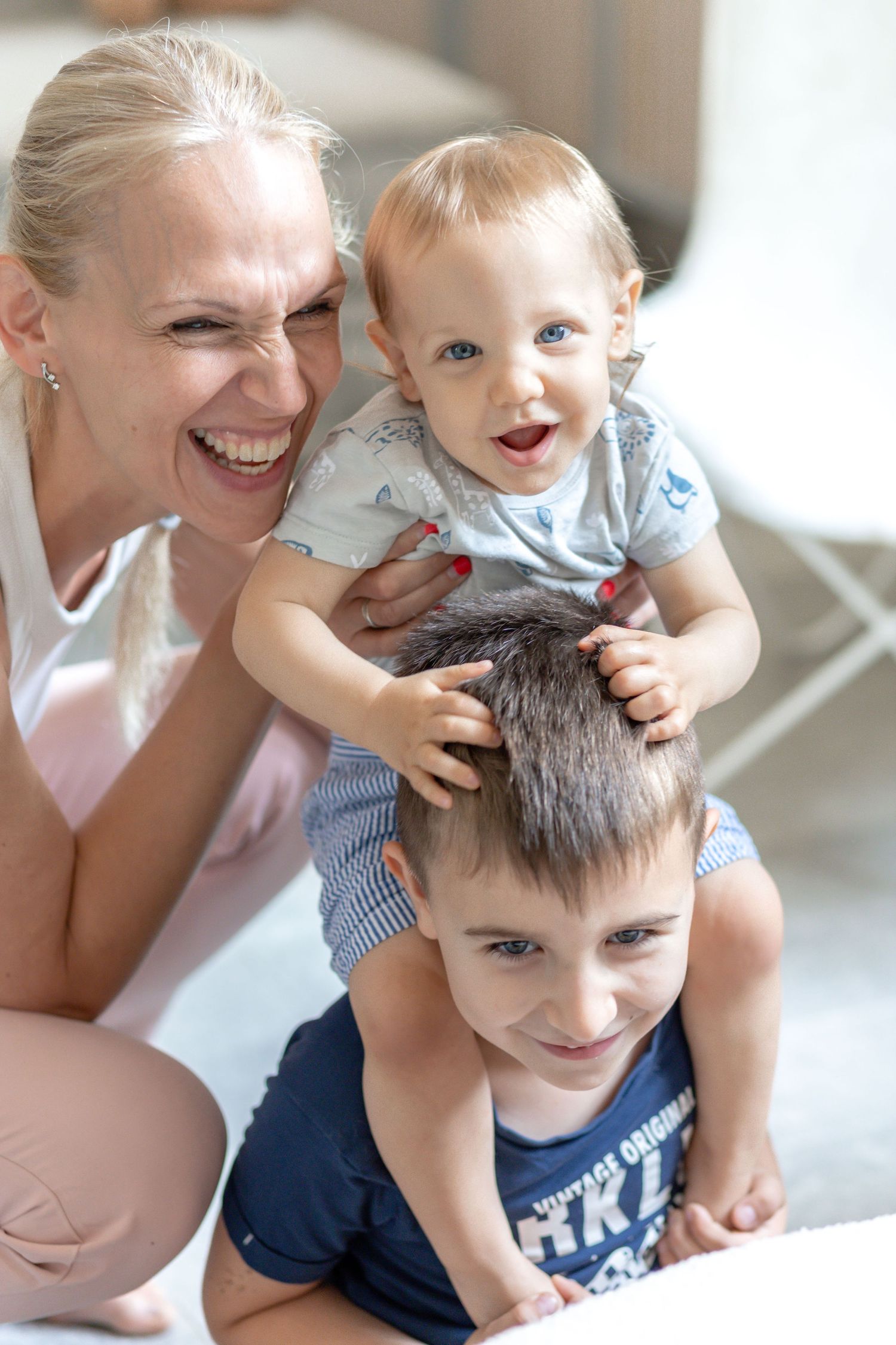 Playful family moment captured in bright indoor setting with natural lighting.
