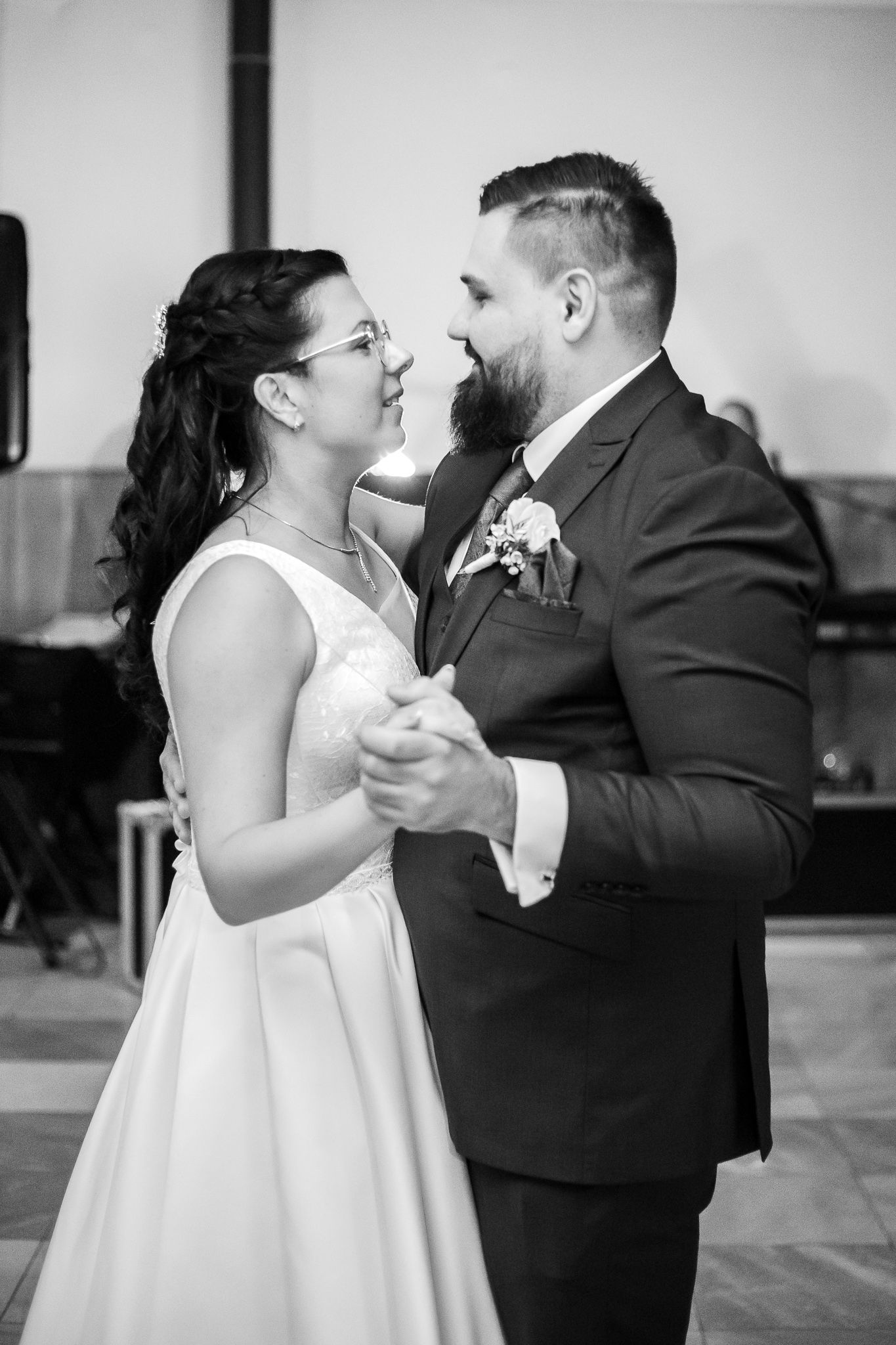 A black and white photo sequence captures a romantic first dance between newlyweds at their wedding reception.