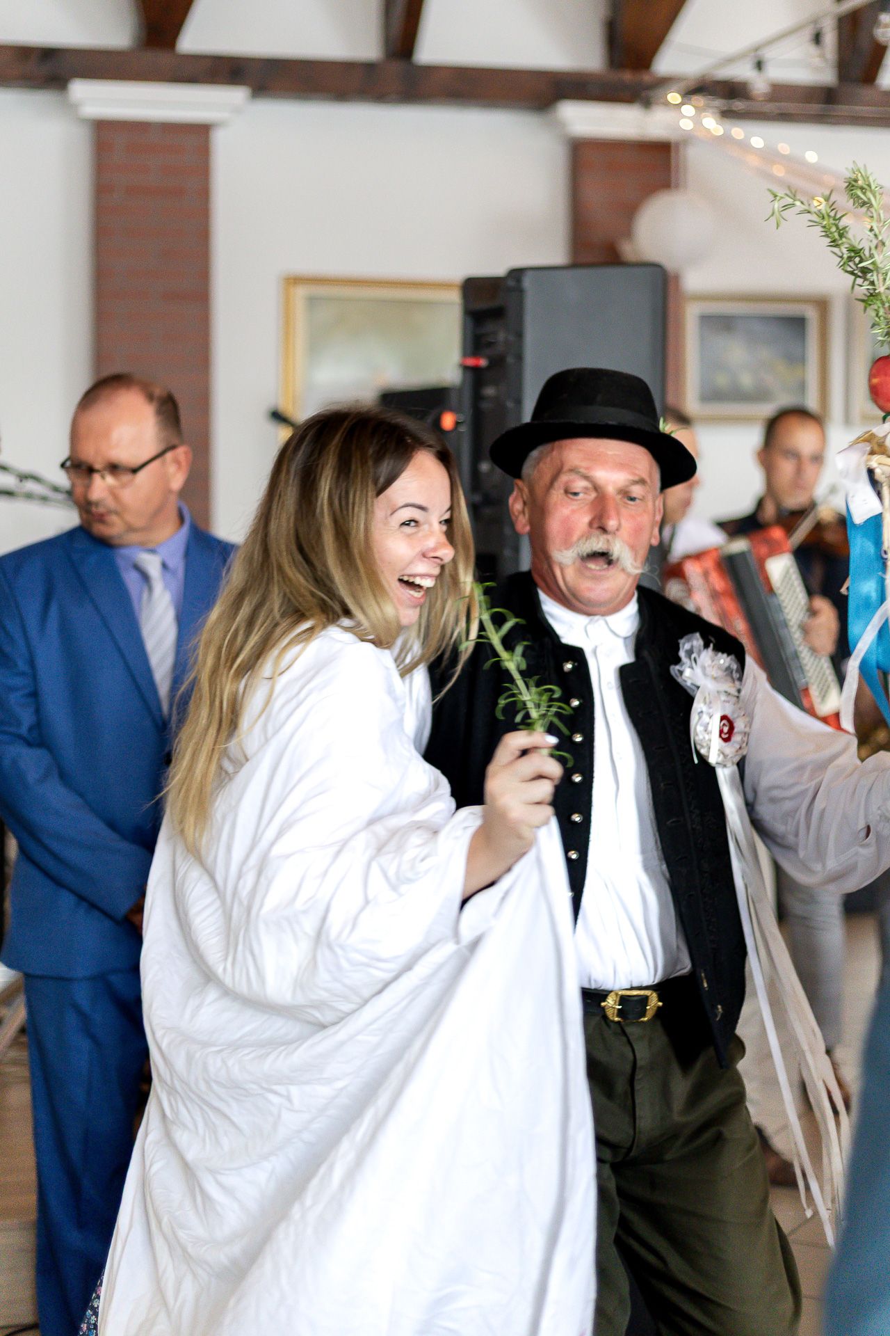 Two people share a celebratory dance moment at what appears to be a formal event or reception.