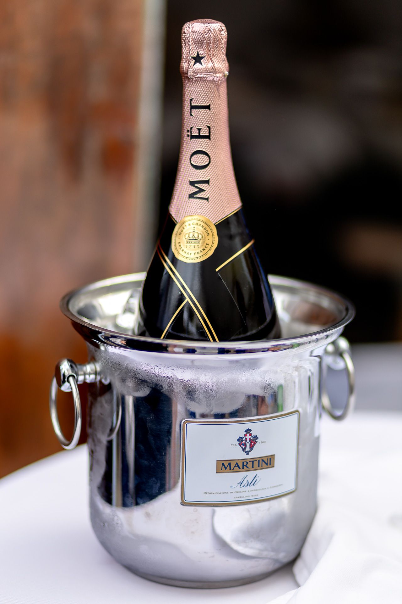 Champagne bottle chilling in silver ice bucket shown in sequence of close-up detail shots.