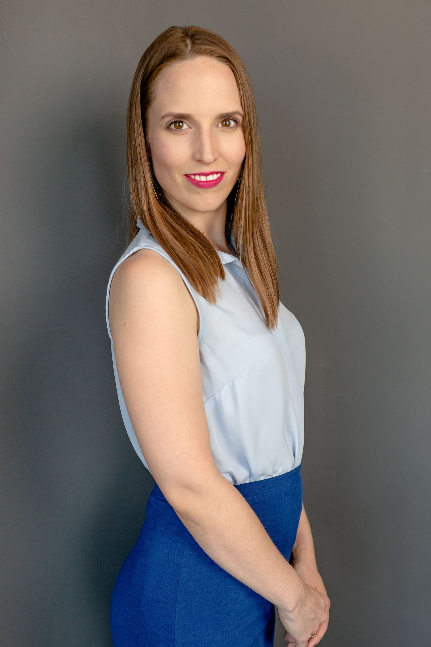 A sleeveless light blue top paired with royal blue skirt is styled against a grey background.