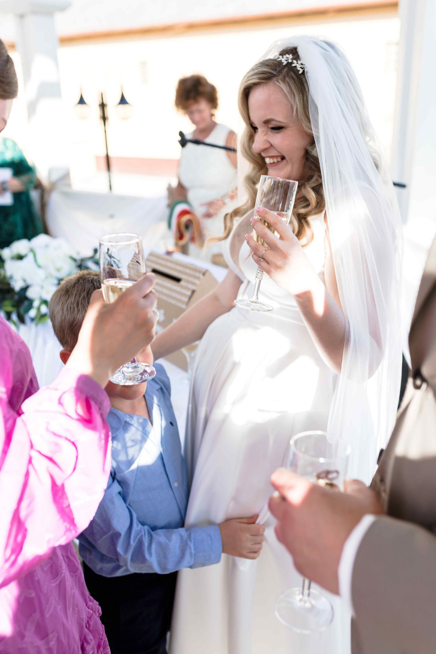 A group of wedding guests enjoying drinks and socializing at an indoor reception celebration.