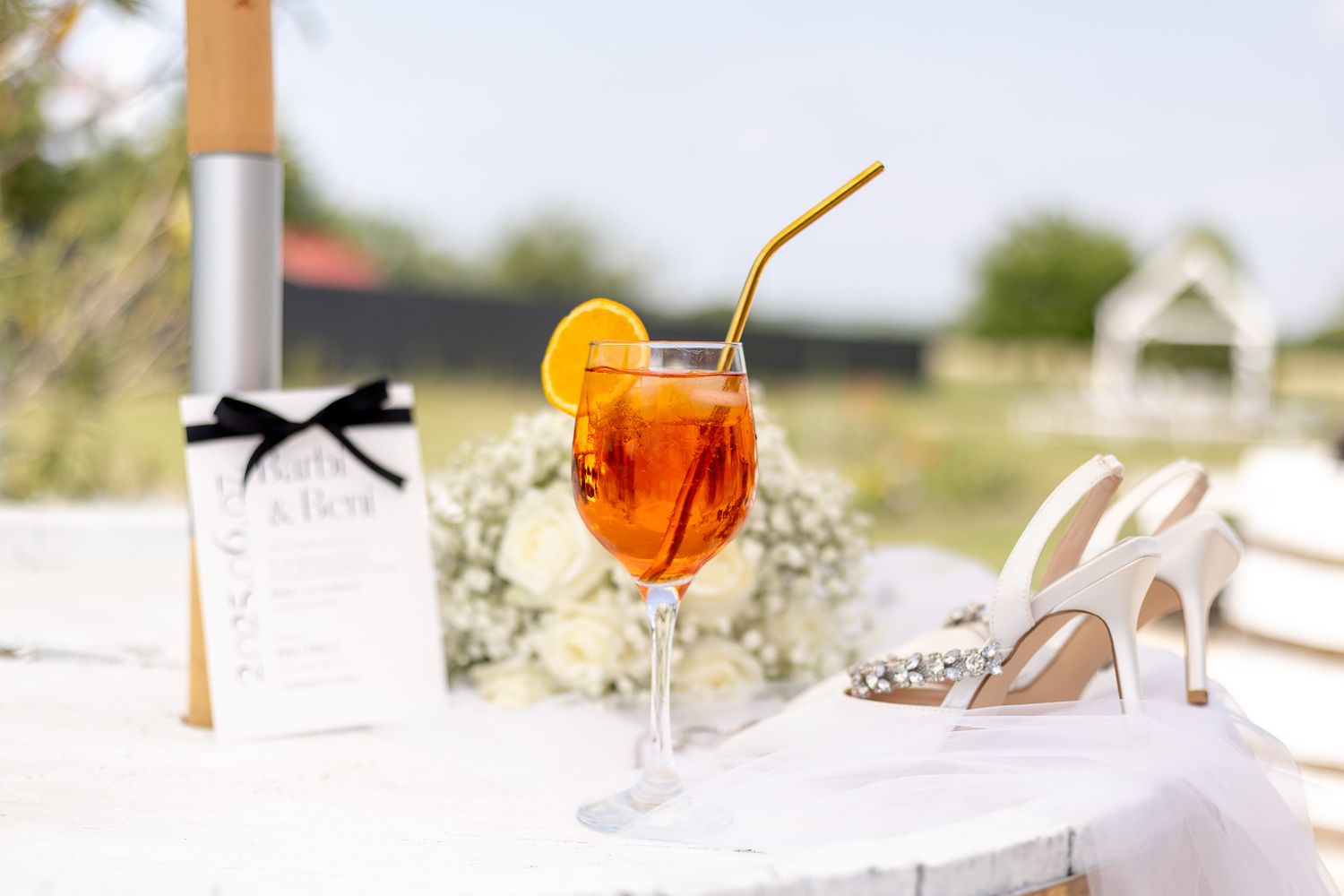 Wedding details featuring orange cocktails and elegant bridal accessories.