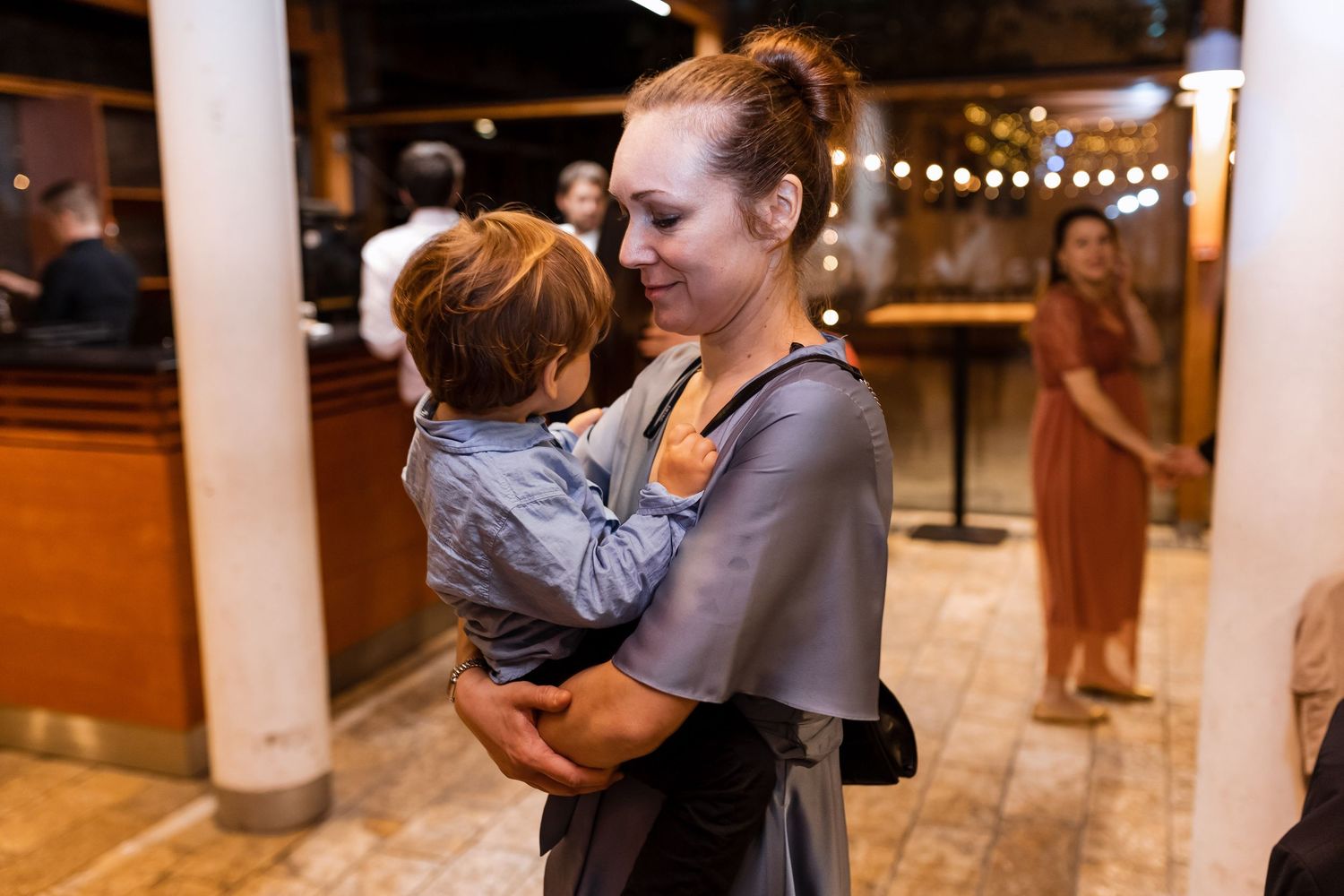 Two people dancing together in an intimate slow dance under soft lighting at an indoor venue.