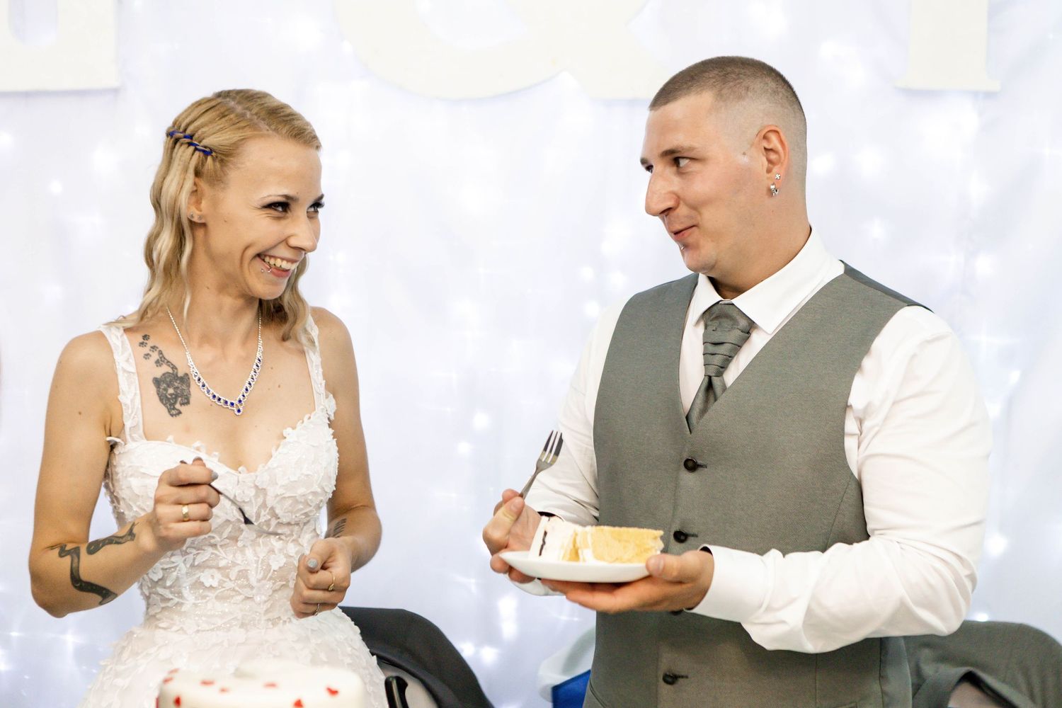A bride and groom enjoy their first dance at their wedding reception while guests watch in the background.