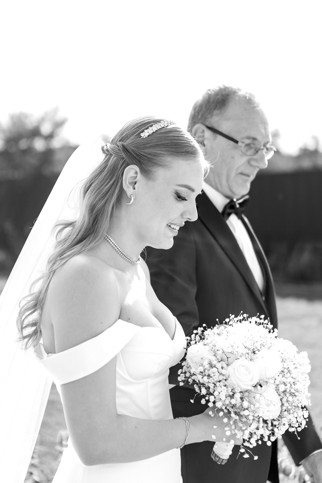 Black and white wedding portraits capture bride with baby's breath bouquet in elegant poses.