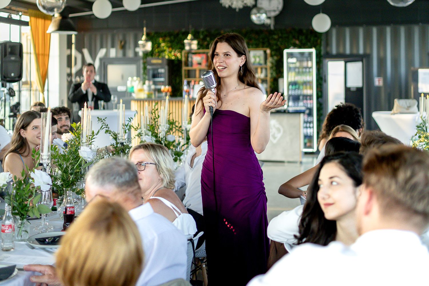 Wedding guests enjoying festivities in an indoor venue decorated with paper lanterns.