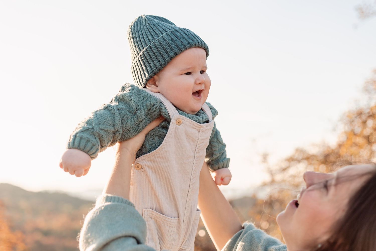 Joyful outdoor family moment captured during sunset with autumn colors.