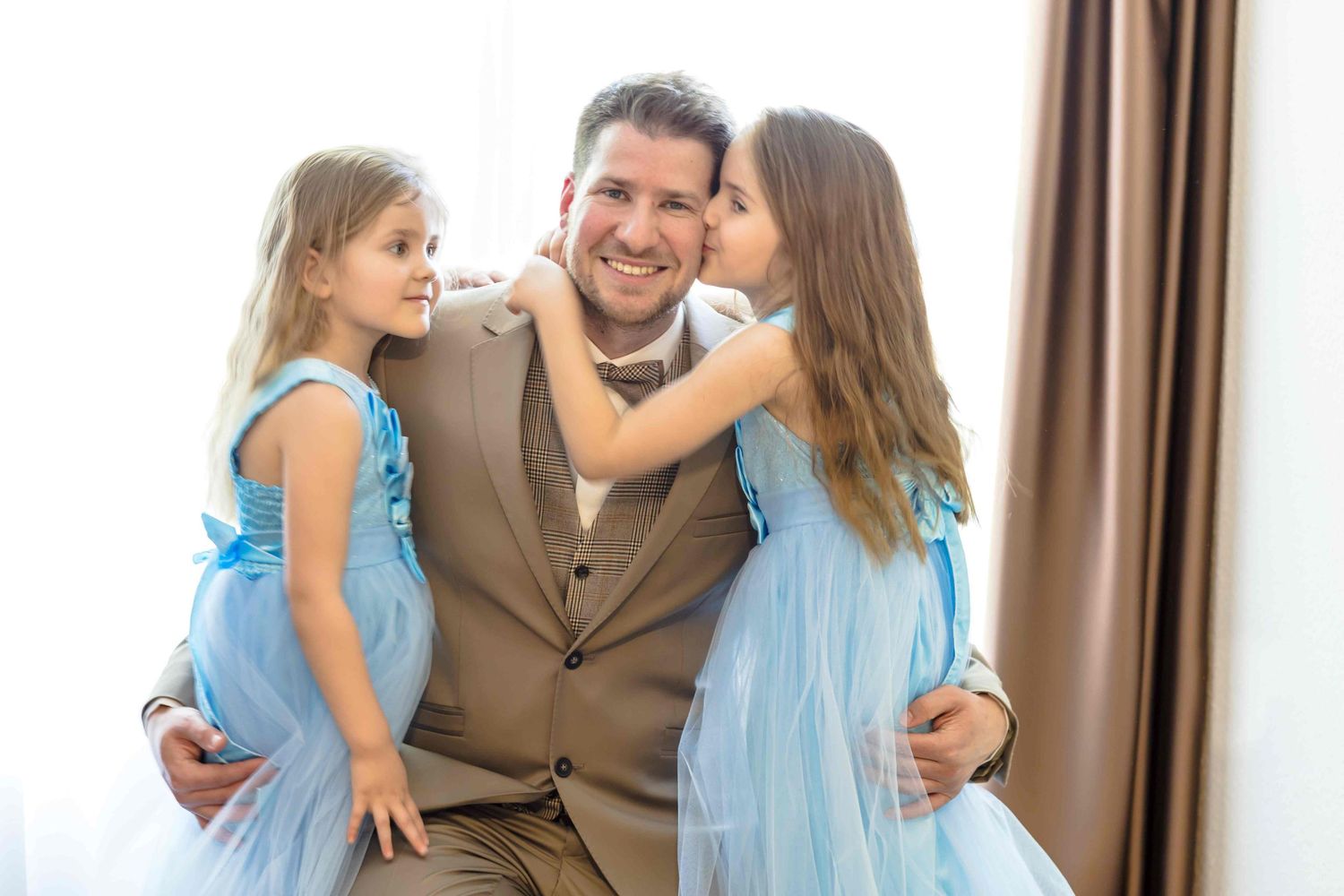 Family members sharing tender moments in matching blue outfits during a photo session.