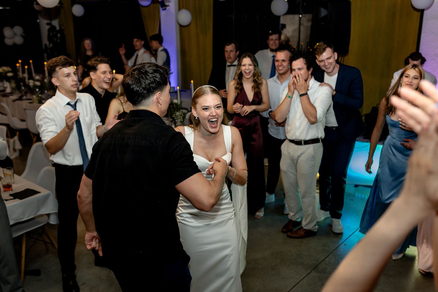 Guests enjoying themselves on a lively wedding reception dance floor.
