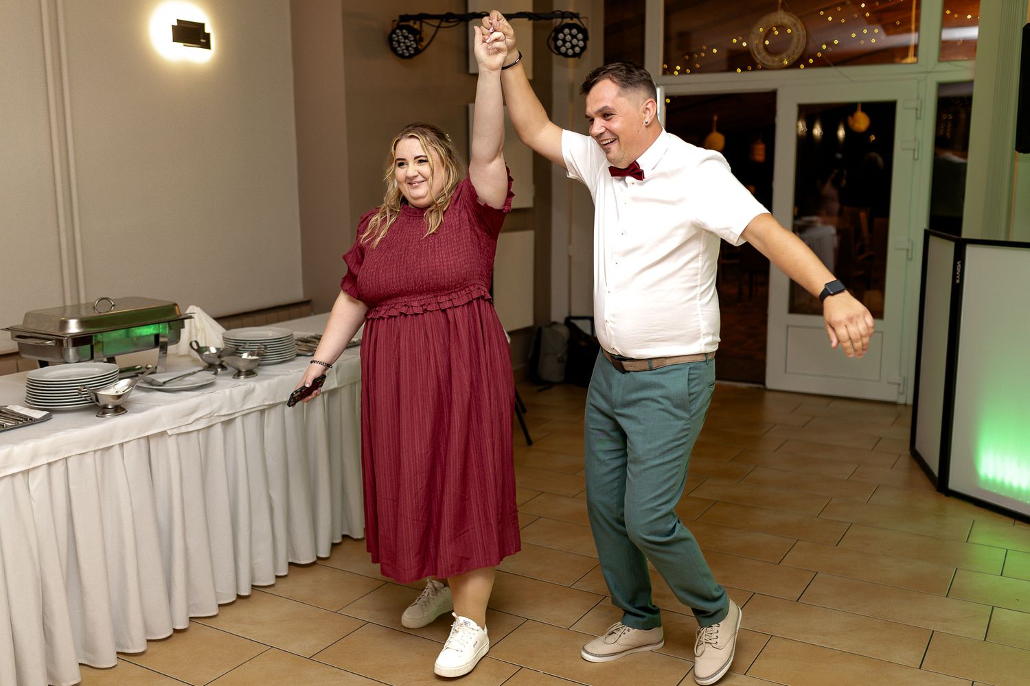 Wedding guests dance together on the dance floor during a reception celebration.