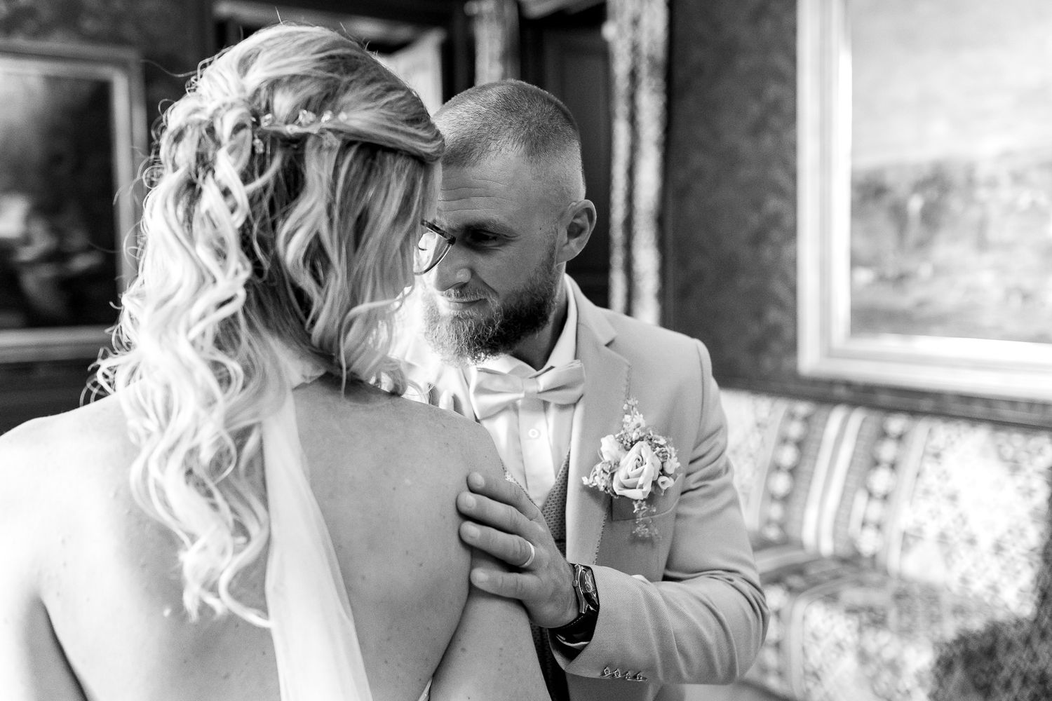 A tender black and white wedding moment captured as a couple shares an intimate exchange during their celebration.