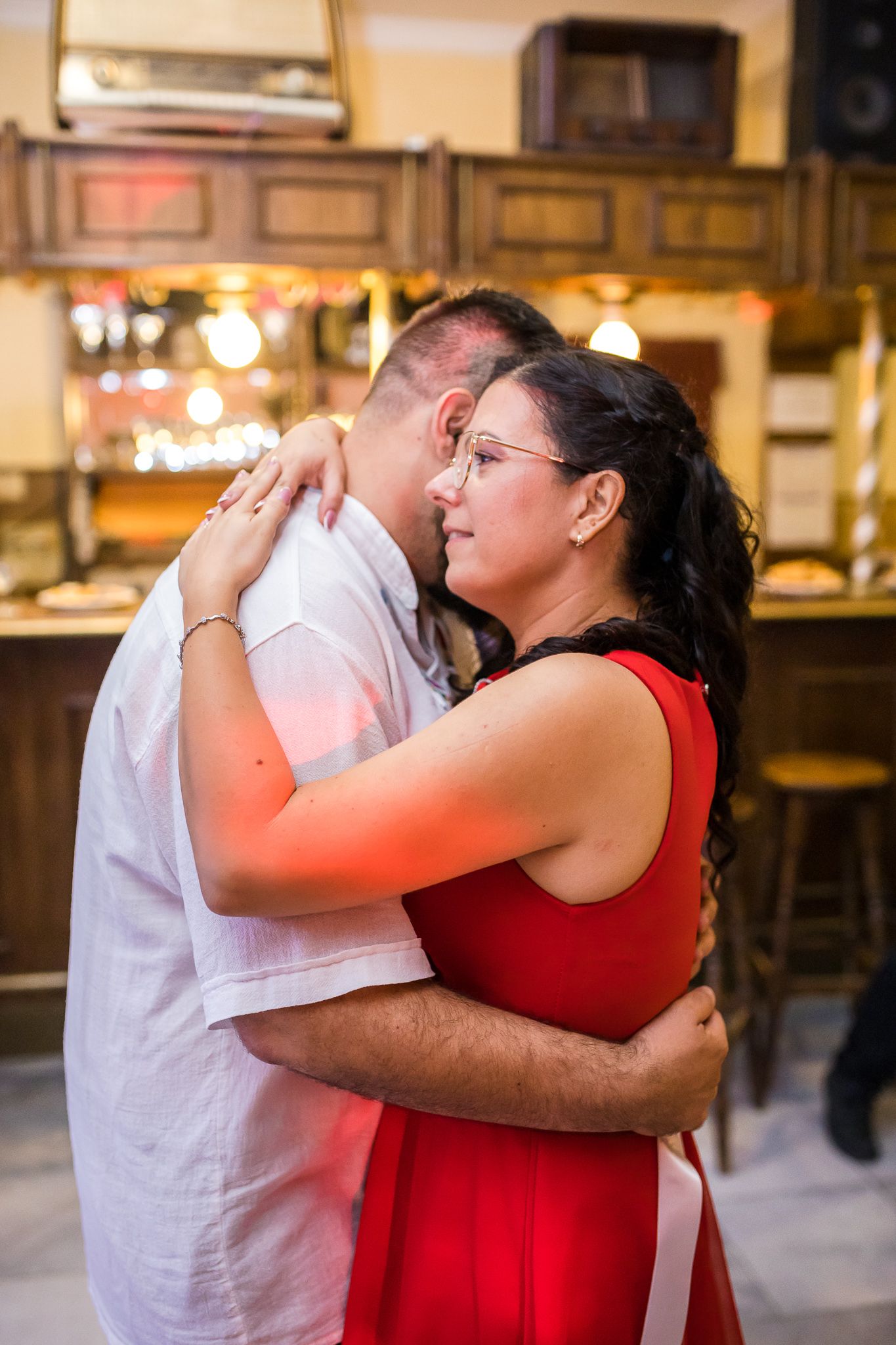 A series of four connected photos showing two people embracing in a warm hug against an indoor background.