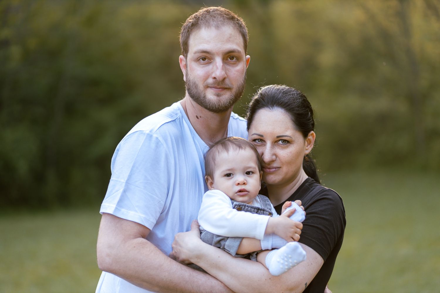 Sweet family moment captured during outdoor photo session at golden hour.