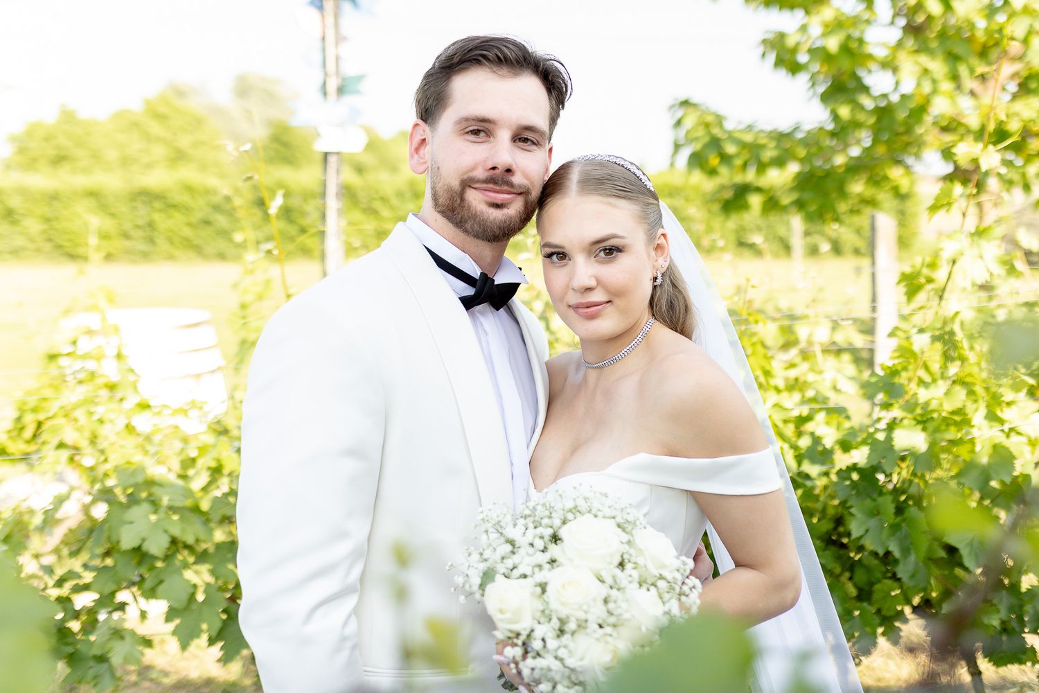 Sunlit wedding portraits in a vineyard showcase romantic moments.