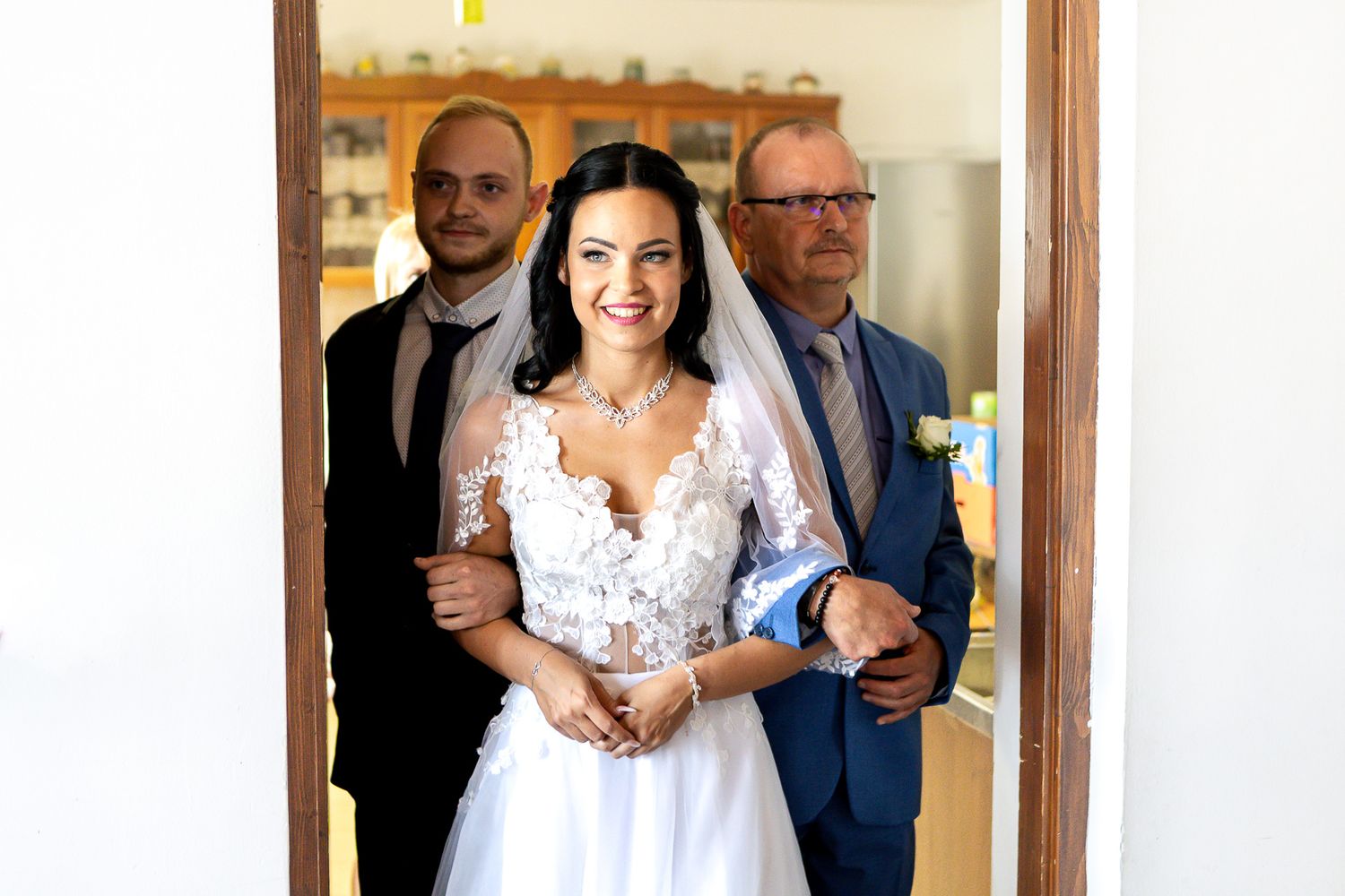 A bride and groom share their first dance at a wedding reception while guests watch from the sidelines.