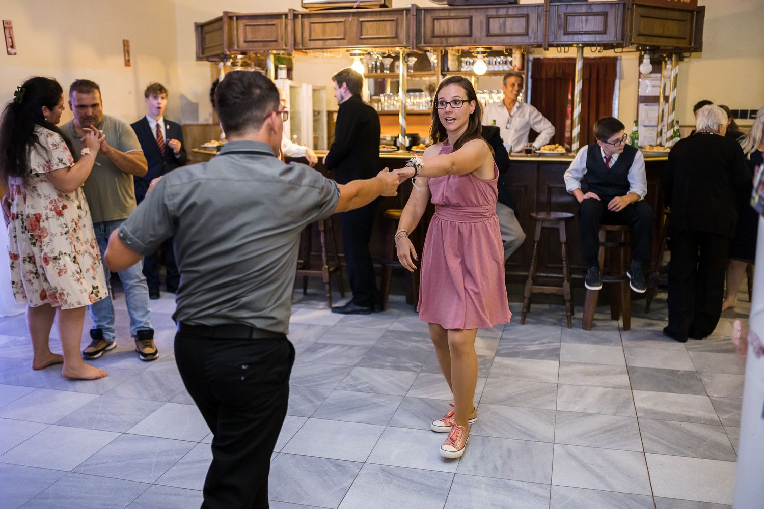 Dancers in formal attire twirl on the dance floor during a celebration event.