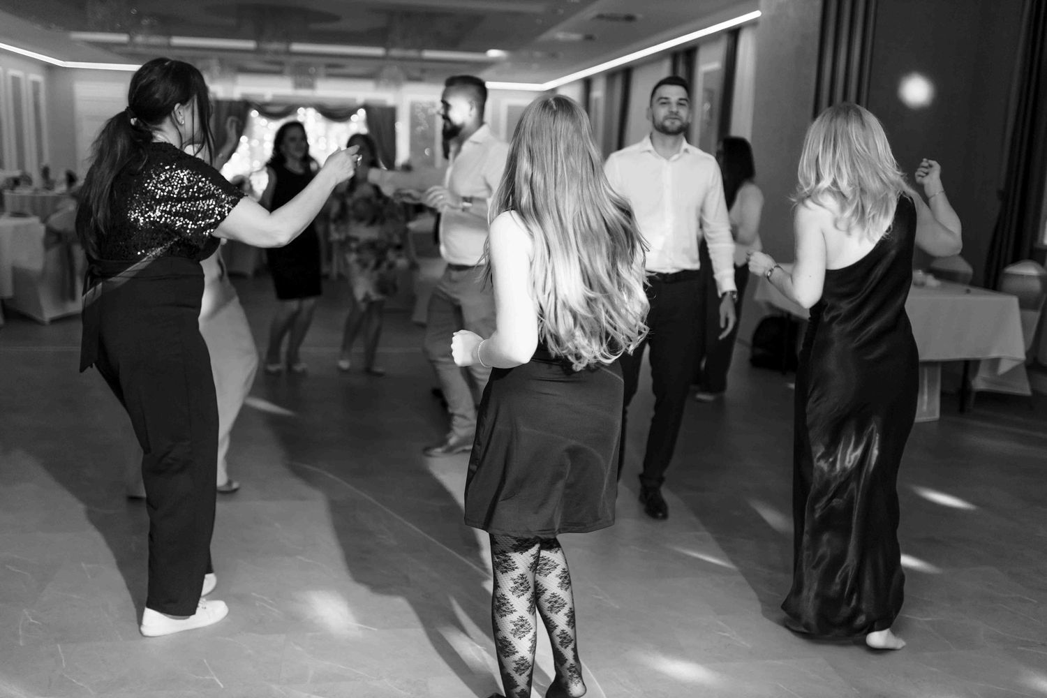 People dancing together at a social dance class in black and white photography.