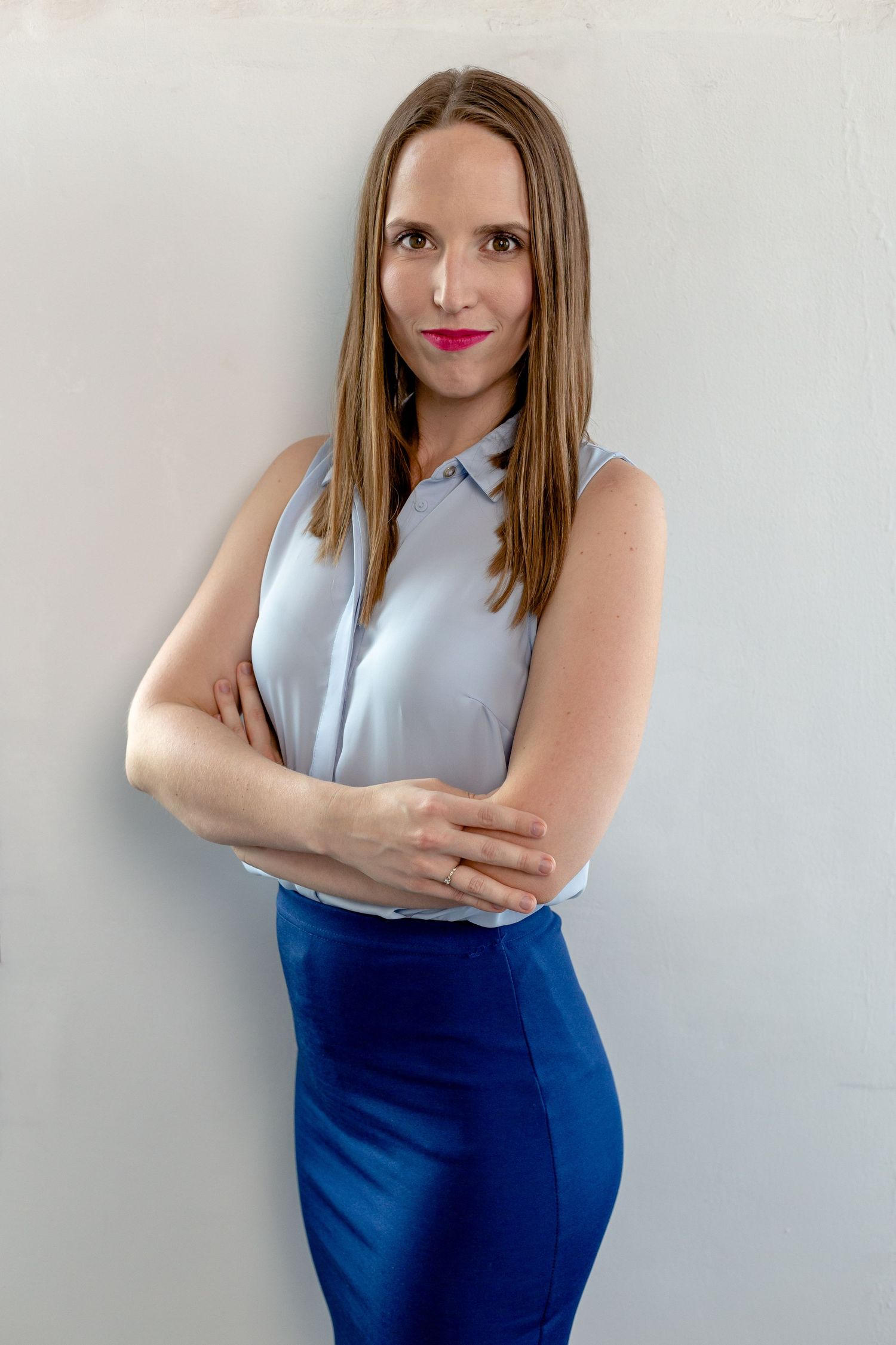 Professional portraits against a white wall showing confident business poses.