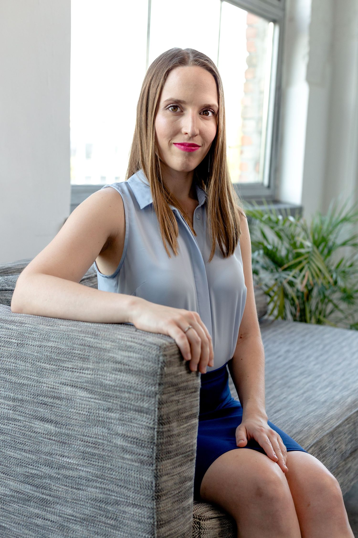 Relaxed business portraits on a modern gray couch with natural lighting.
