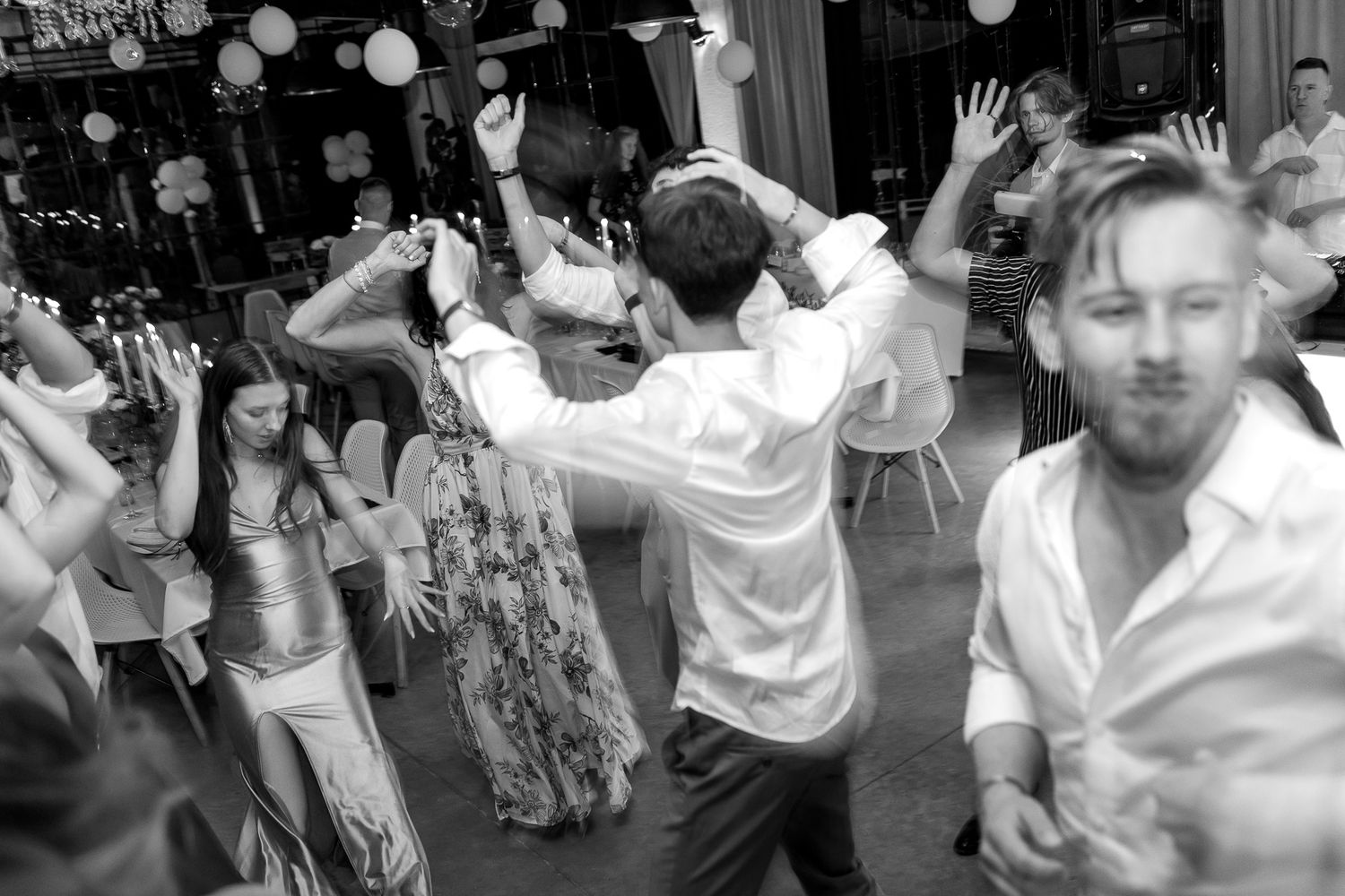 Black and white photo of party guests dancing enthusiastically on the dance floor.