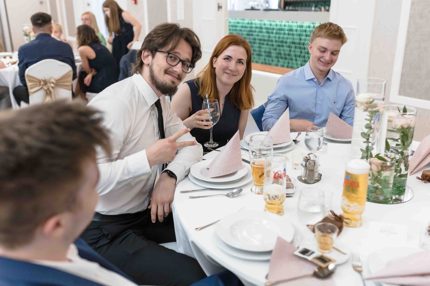 Colleagues gather around a restaurant table for drinks and conversation during a casual business lunch.