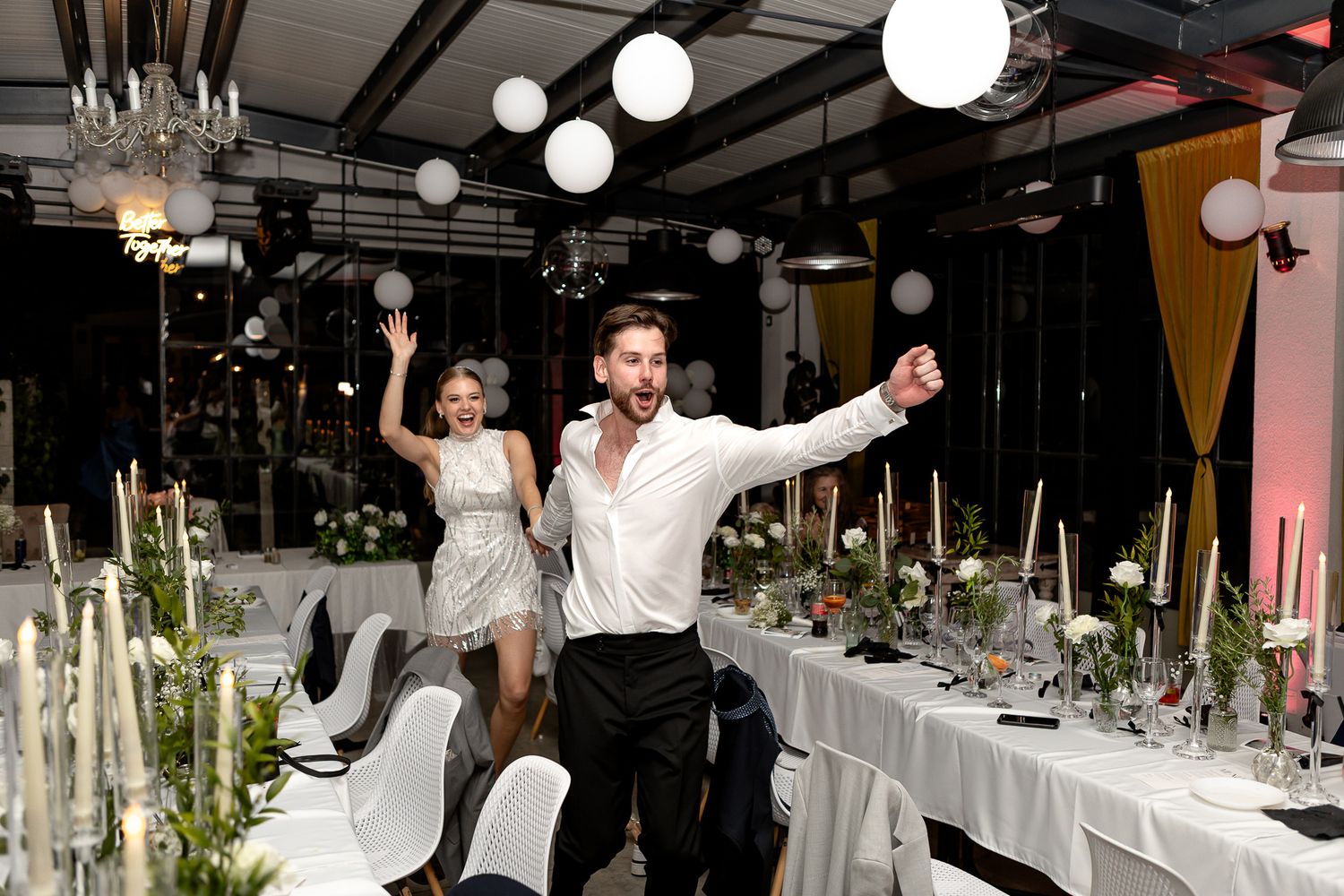 Wedding reception venue with long tables and hanging paper lanterns.