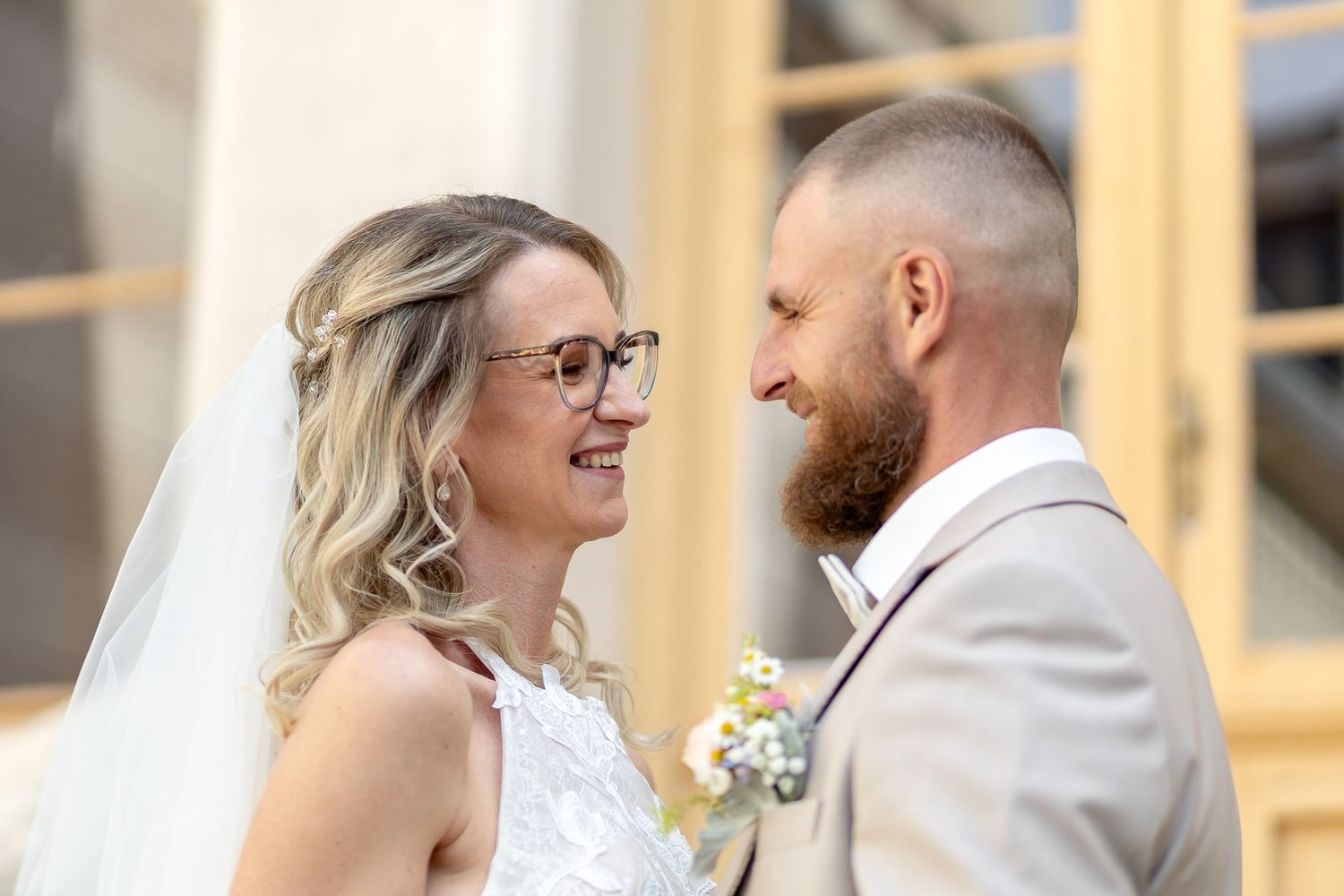 A wedding couple shares intimate moments during their outdoor photo session at a rustic venue.