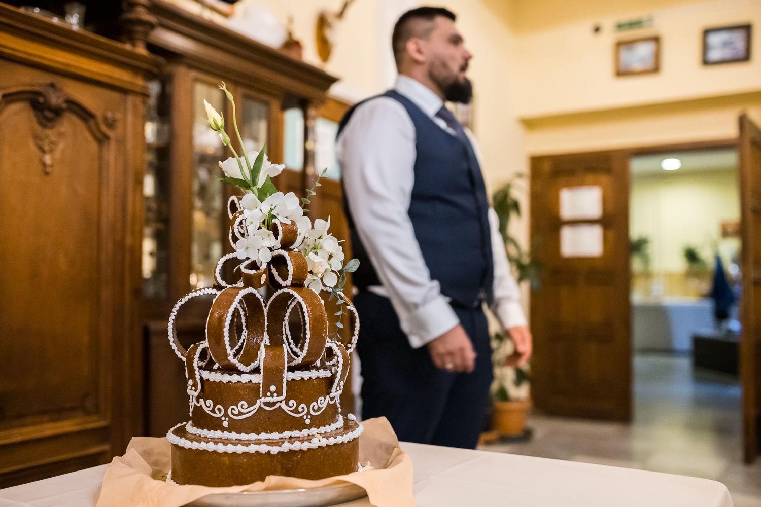 A decorative silver tiara with crystals sits on display in an elegant wooden room setting.