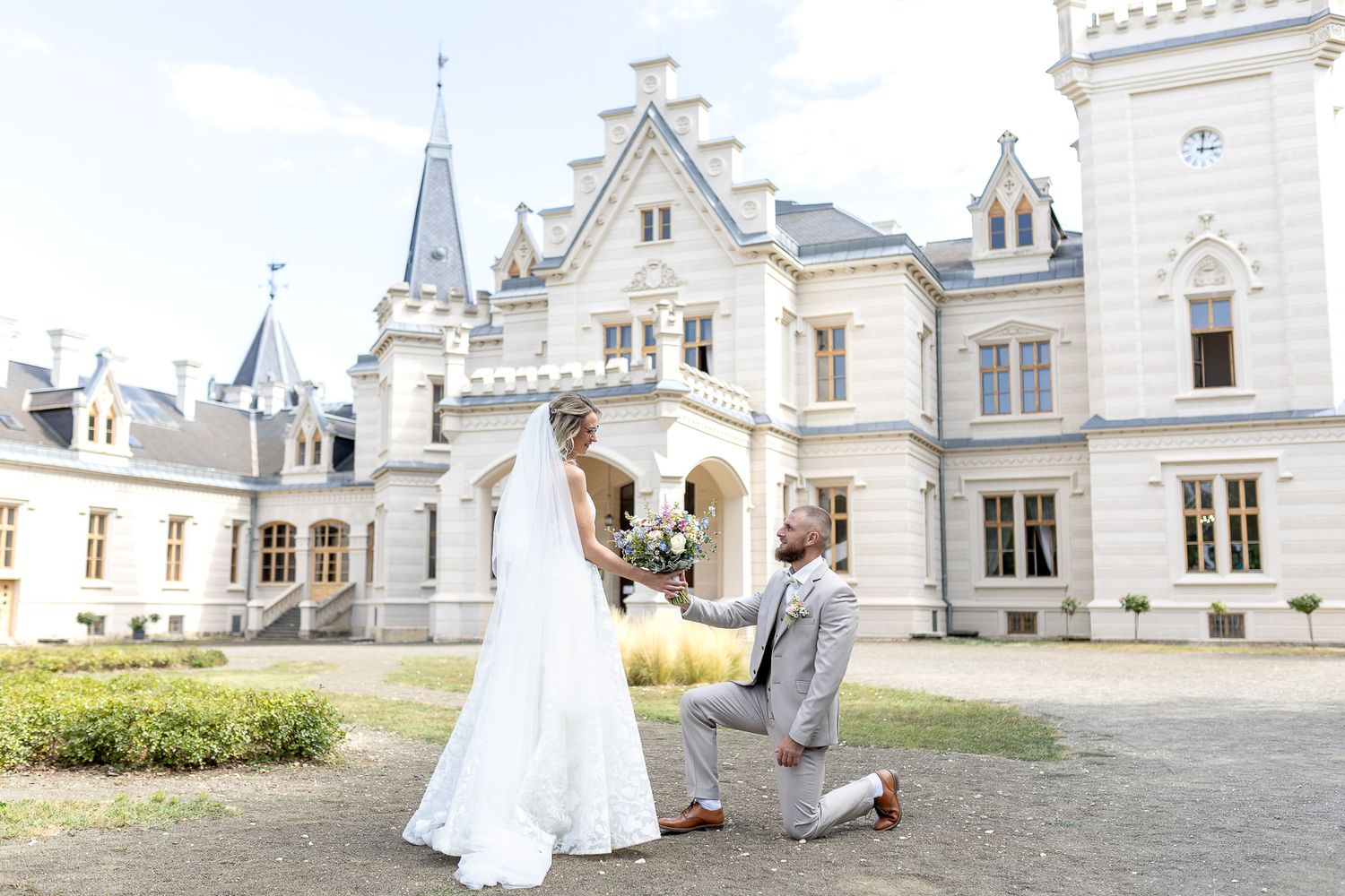 A romantic wedding couple shares tender moments on the grounds of an elegant white mansion estate.