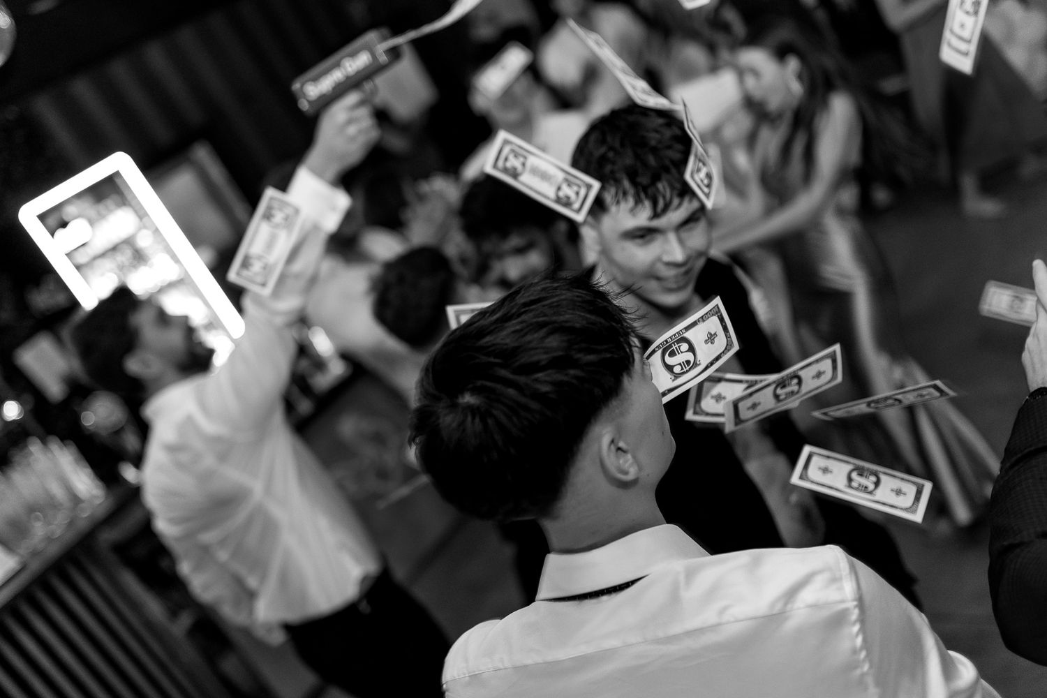 Black and white photo of money being thrown in the air during a celebration.