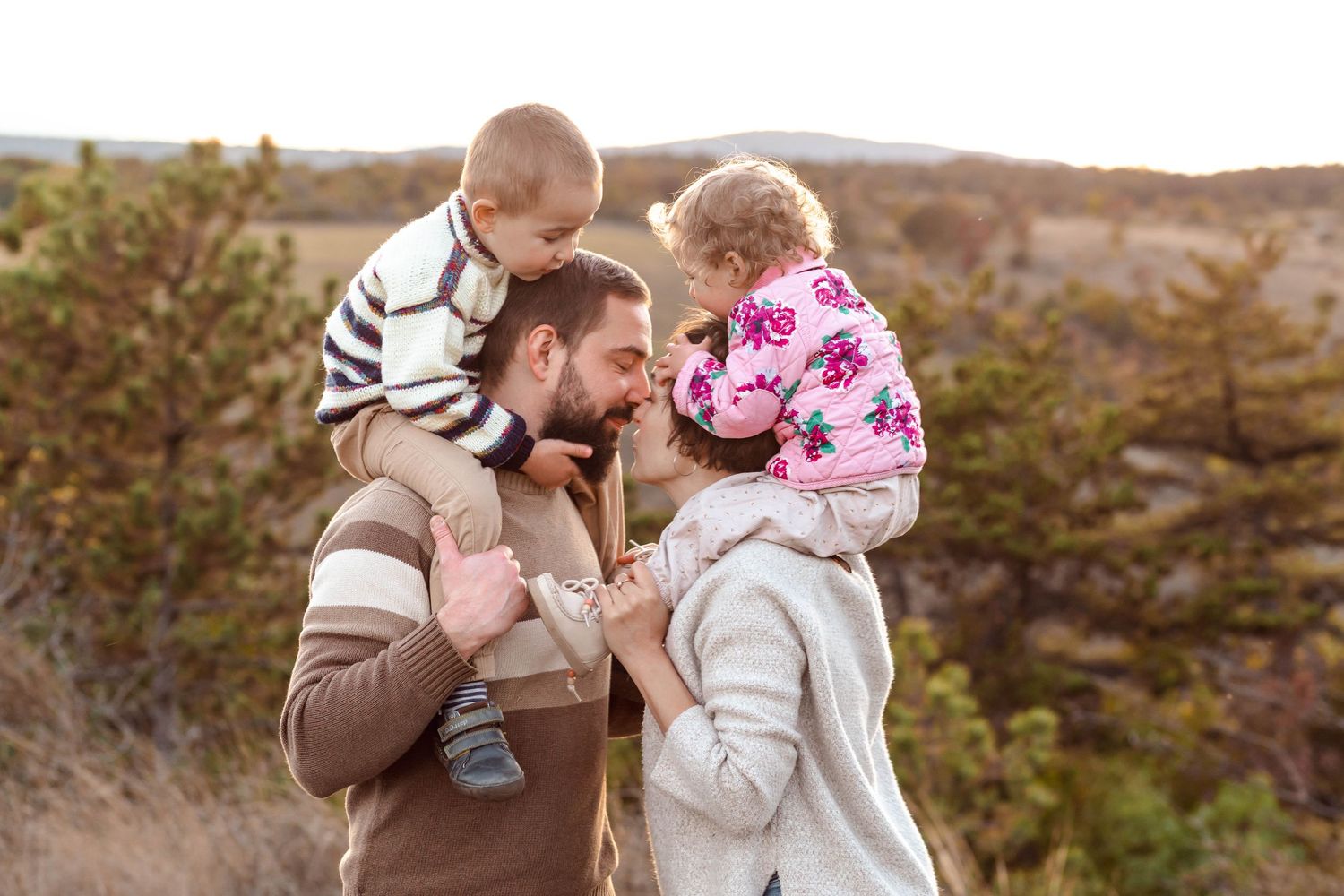Family photo series showing tender moments between parents and children in an outdoor setting at sunset.