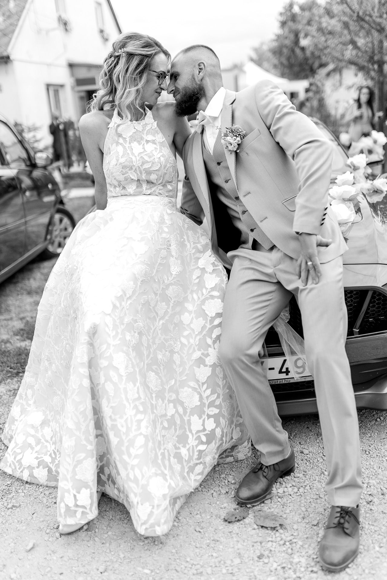 A series of black and white wedding photos showing the bride's lace dress and groom's boots in romantic poses.