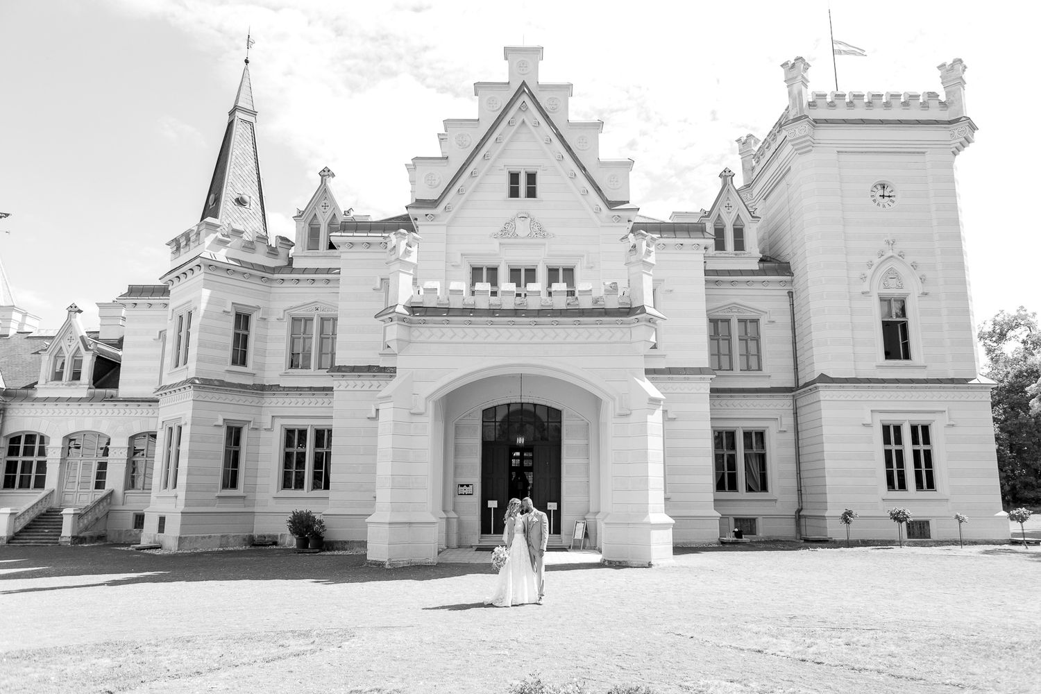 A series of white historic buildings with ornate architectural details and gabled roofs form a panoramic view.