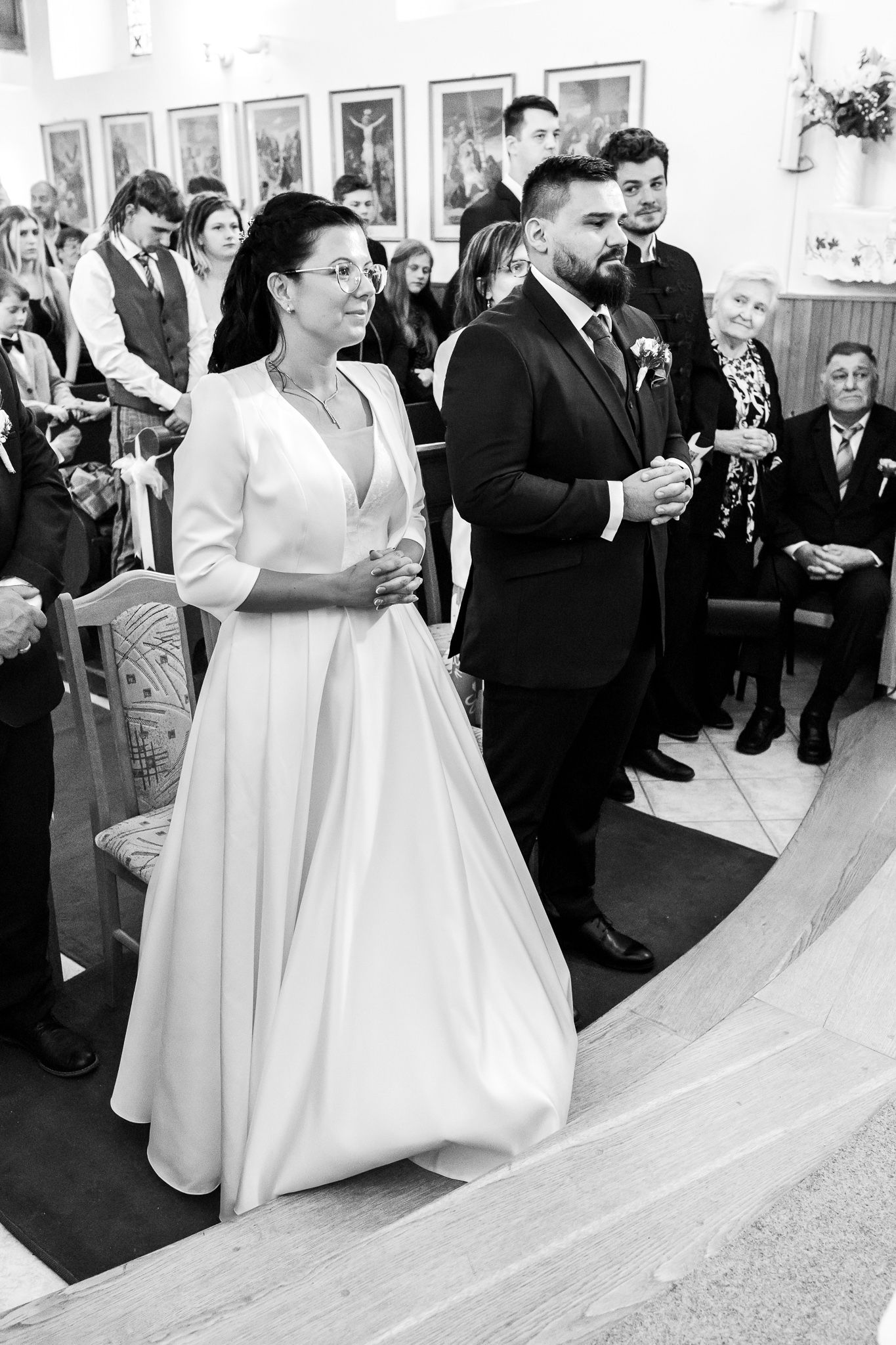 A bride in a white ball gown moves gracefully through a reception venue while guests look on during the celebration.