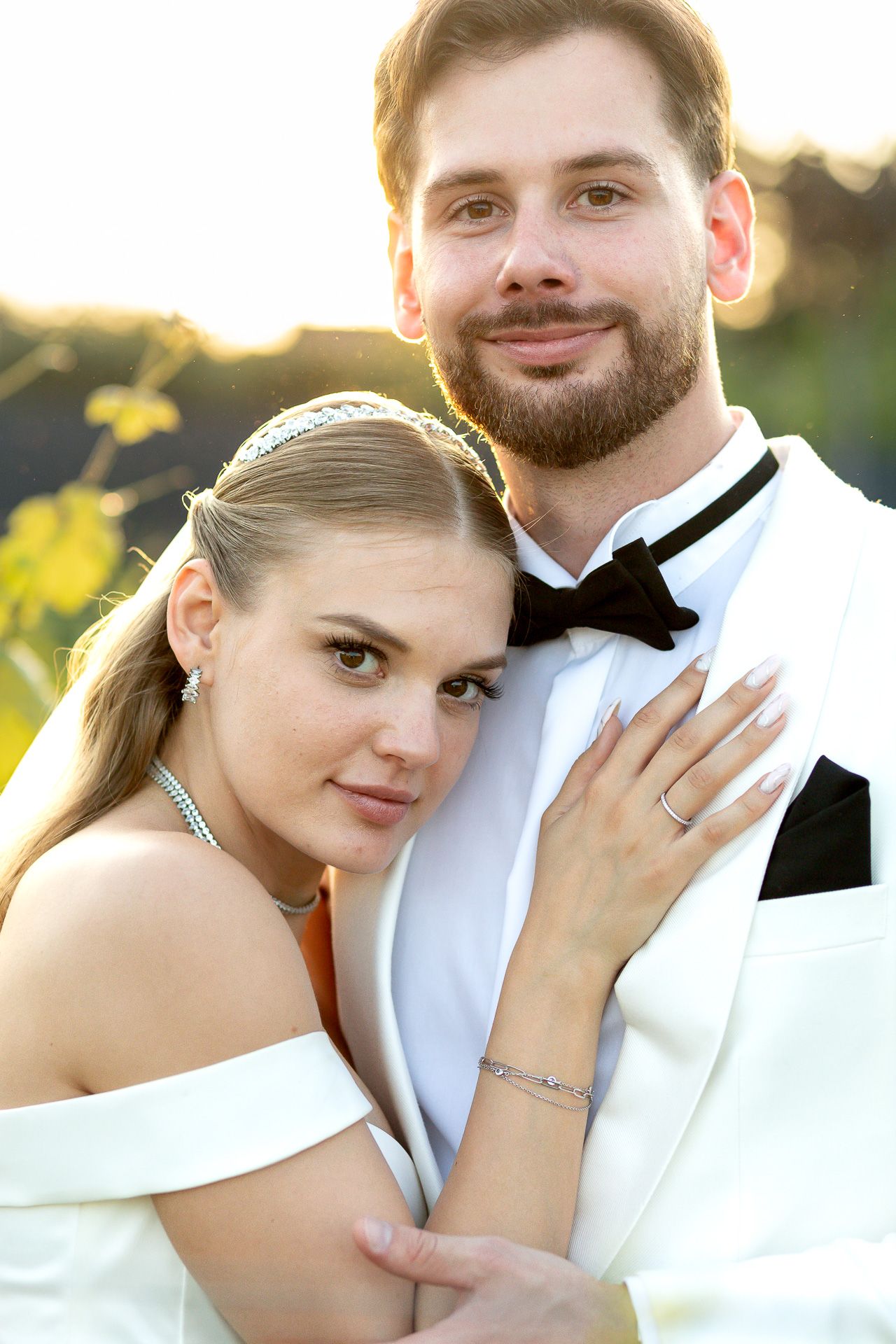 Wedding couple shares intimate moments in warm sunset lighting.