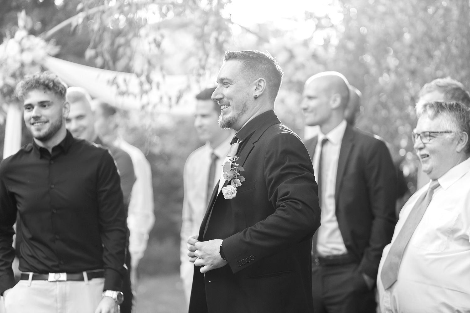 A series of black and white wedding photos showing candid moments between guests and the wedding party during a celebration.