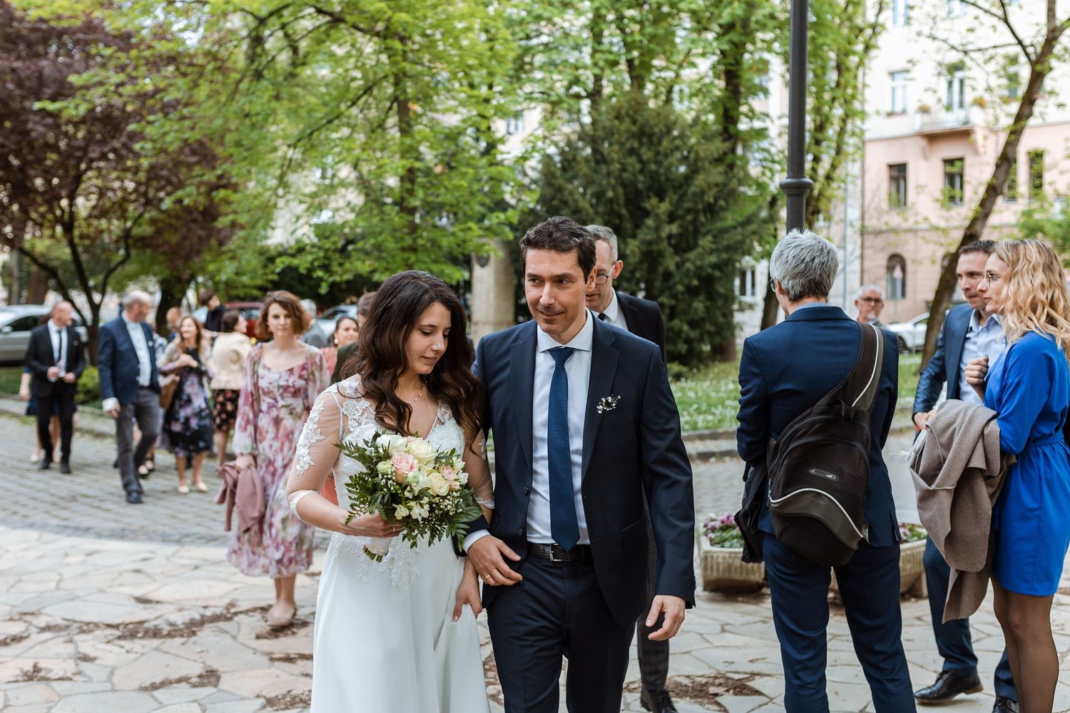 Wedding guests mingle and socialize outdoors at an elegant garden reception.