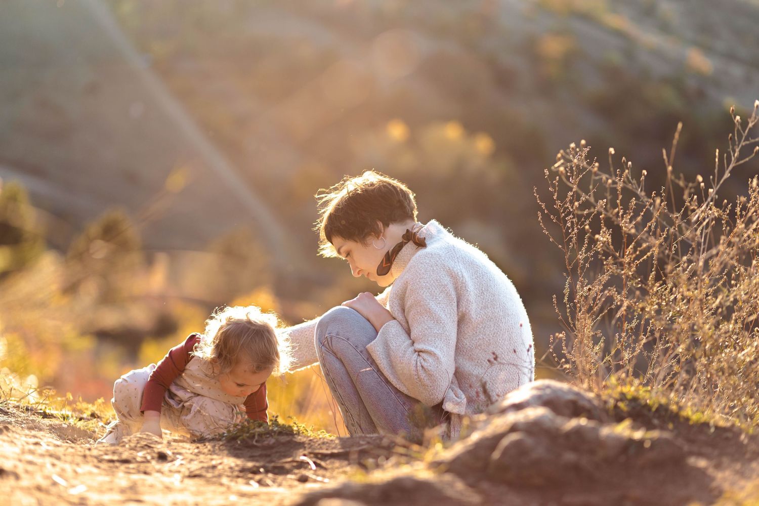 Couple embracing during golden hour photography session in autumn landscape.