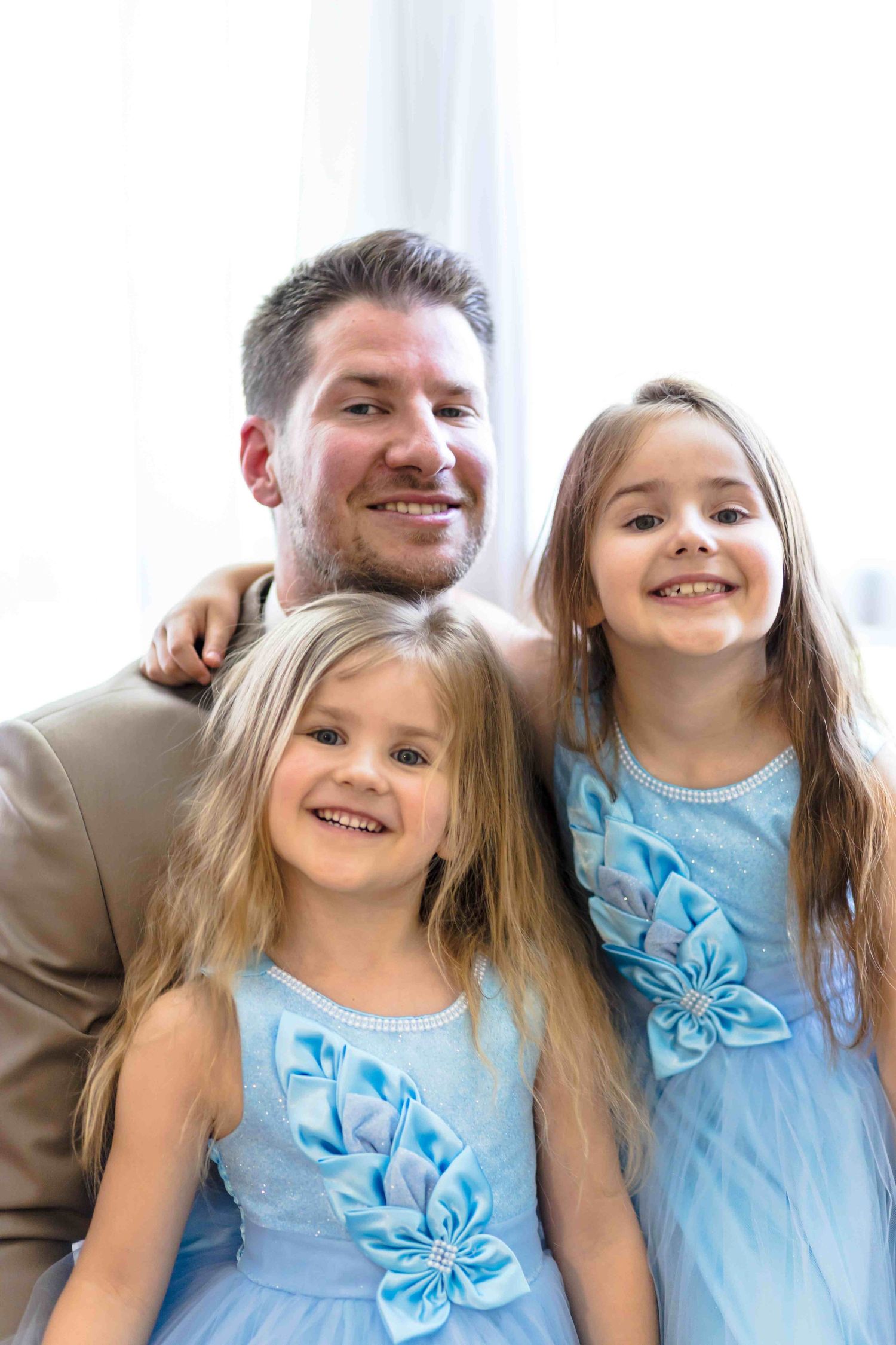 A series of four similar photos showing joyful expressions and light blue dresses with bows.