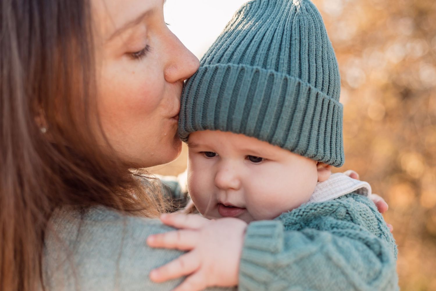 A series of tender moments captured during a fall photoshoot with warm autumn colors in the background.