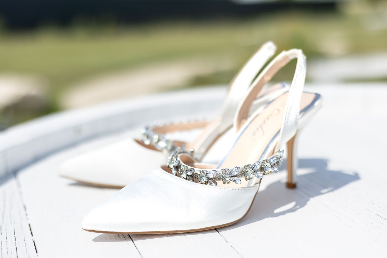 Elegant white heels and decorative elements arranged on a light surface.