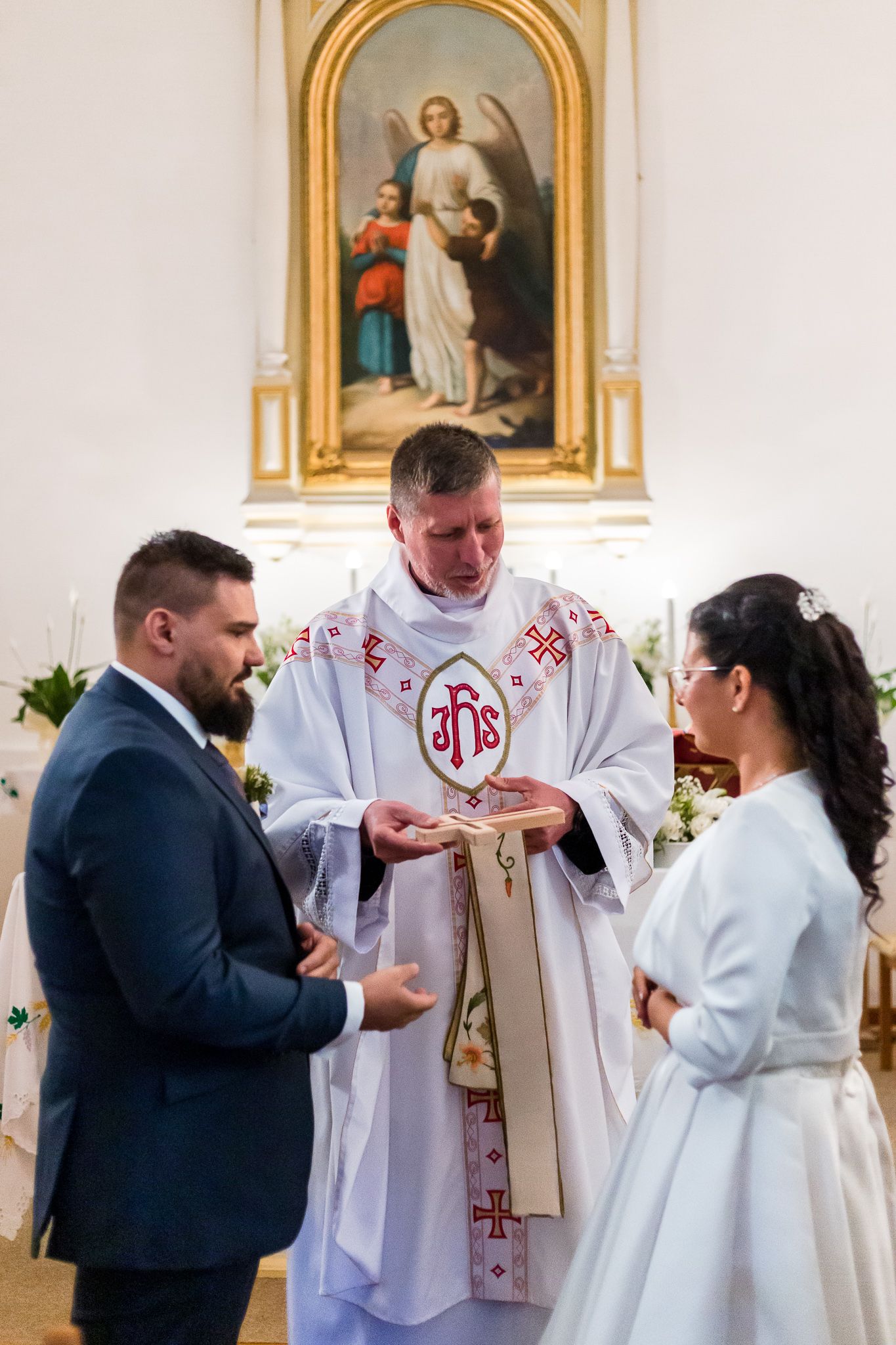 A series of four photos showing a Catholic First Communion ceremony with a priest and participants in a church setting.