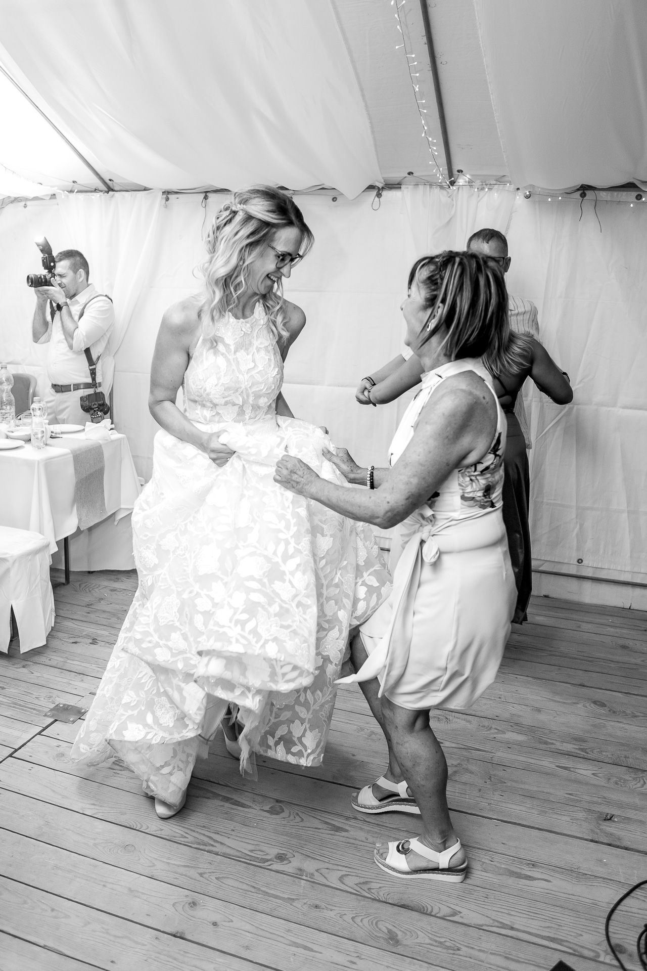 Black and white sequence of dancers twirling and moving together on a wooden floor during a celebration.
