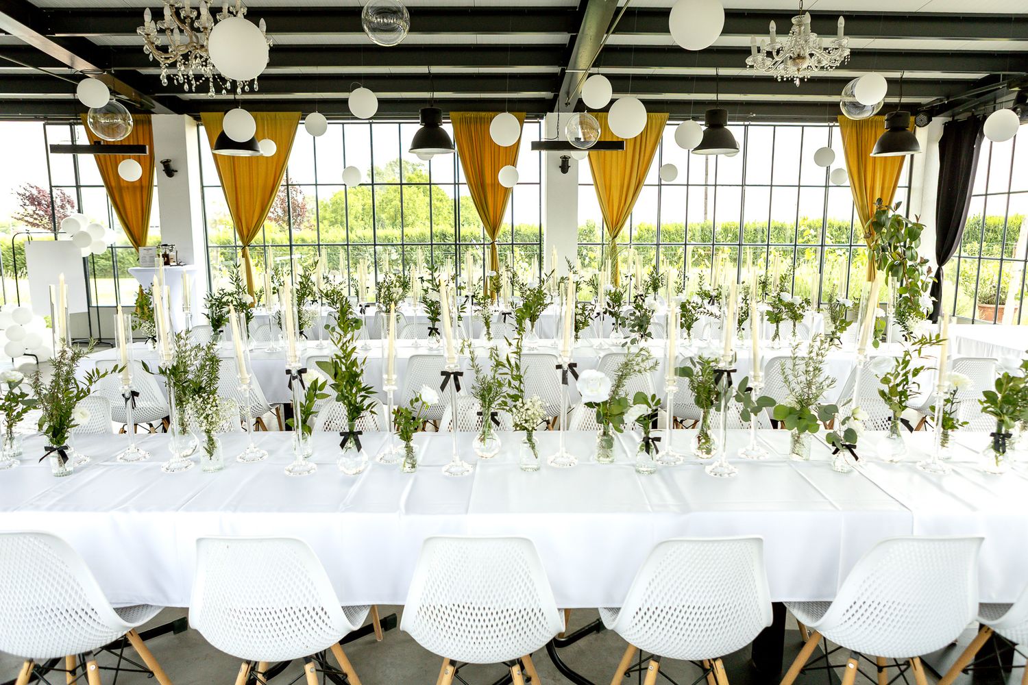 Elegant wedding venue with hanging lights and orange pennant banners decorating the ceiling.