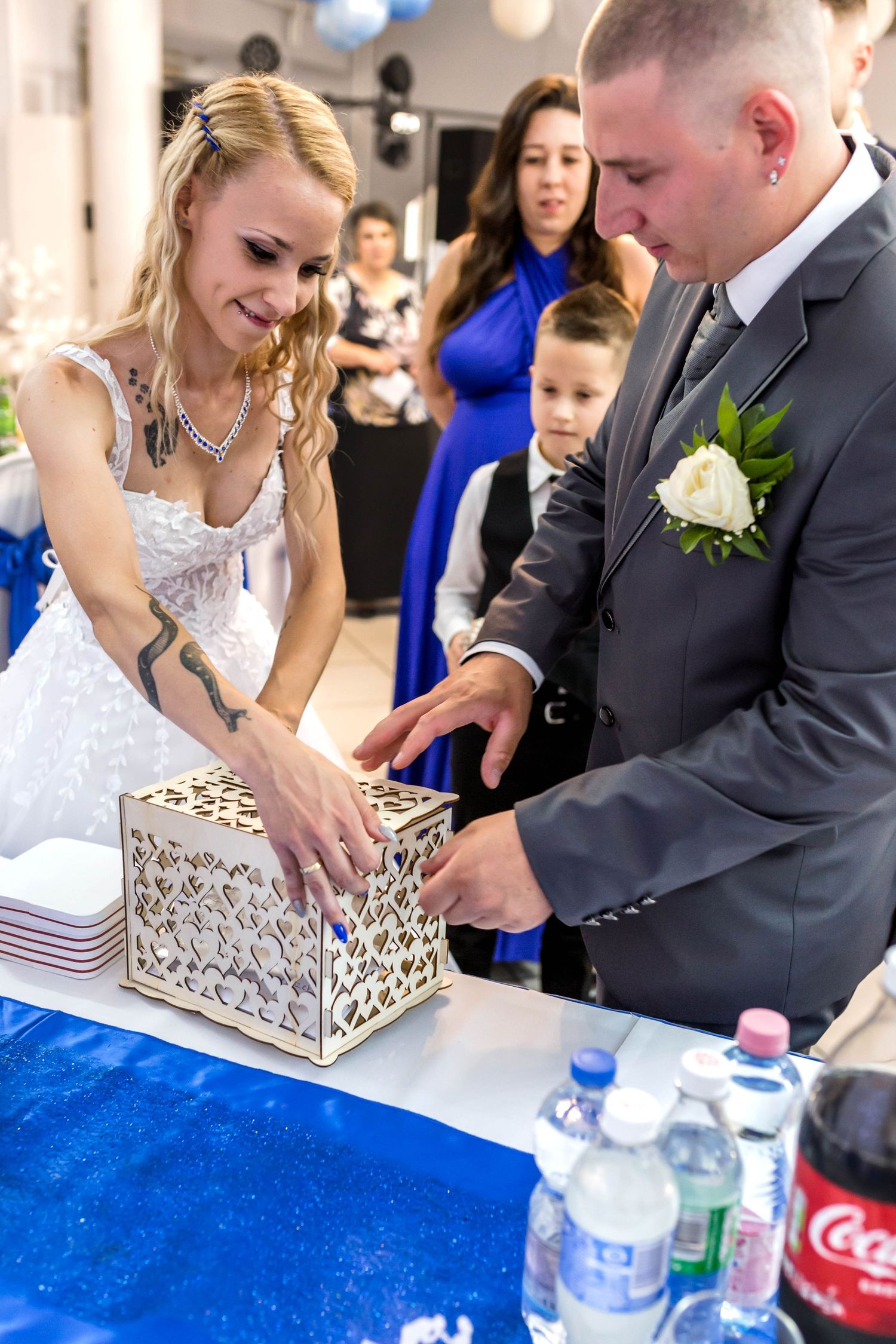 Wedding couple works together to open an ornate silver keepsake box during their reception celebration.