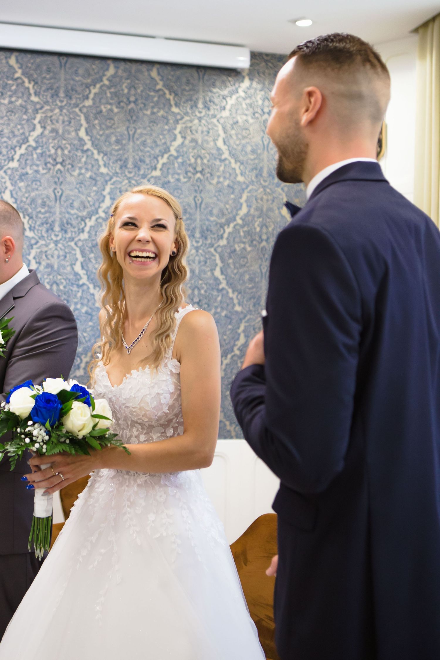 A series of wedding photos showing a first look moment between a bride in white and groom in navy blue suit.
