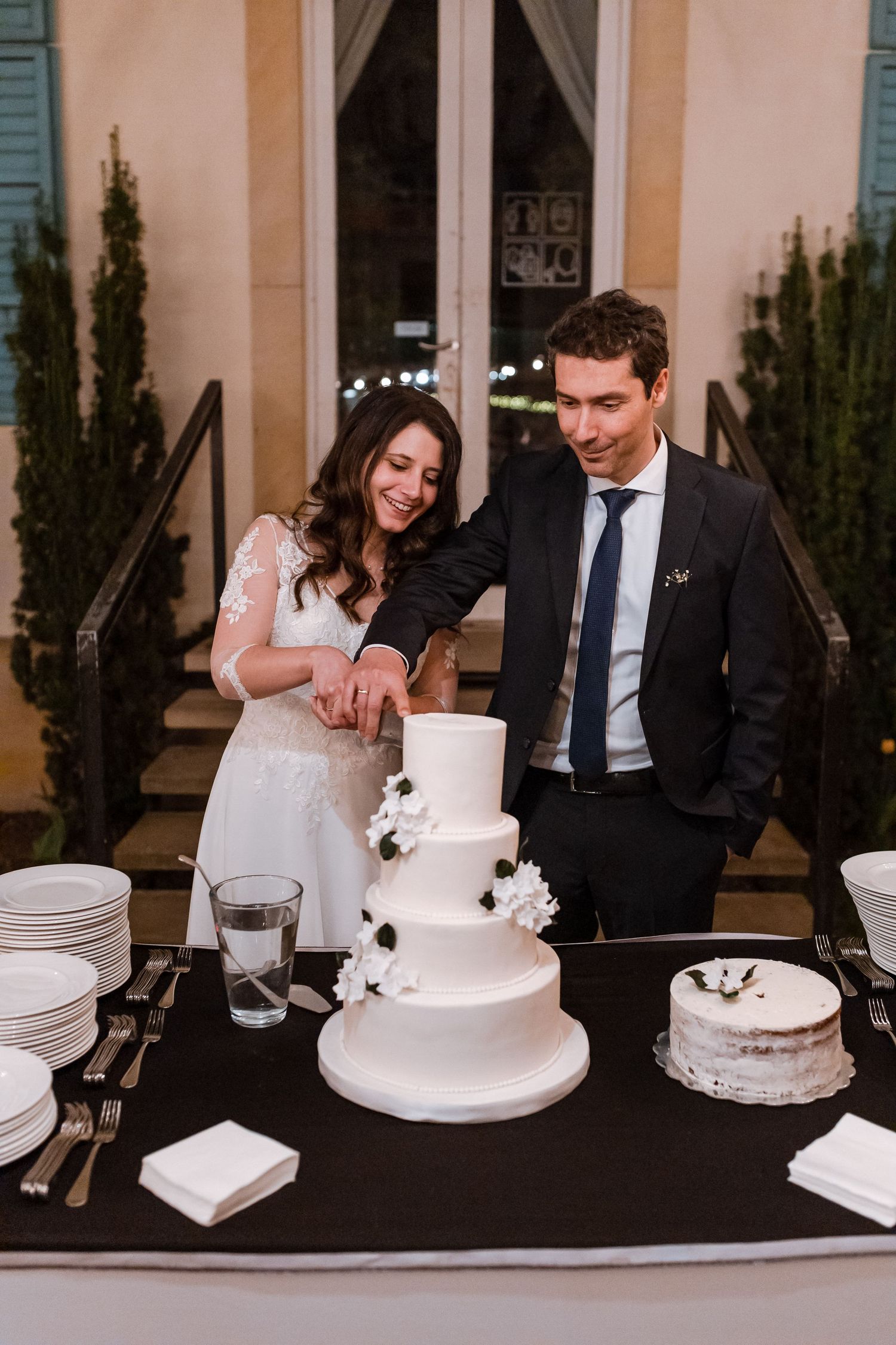 A sequence of photos showing a couple cutting their elegant white wedding cake at their reception.