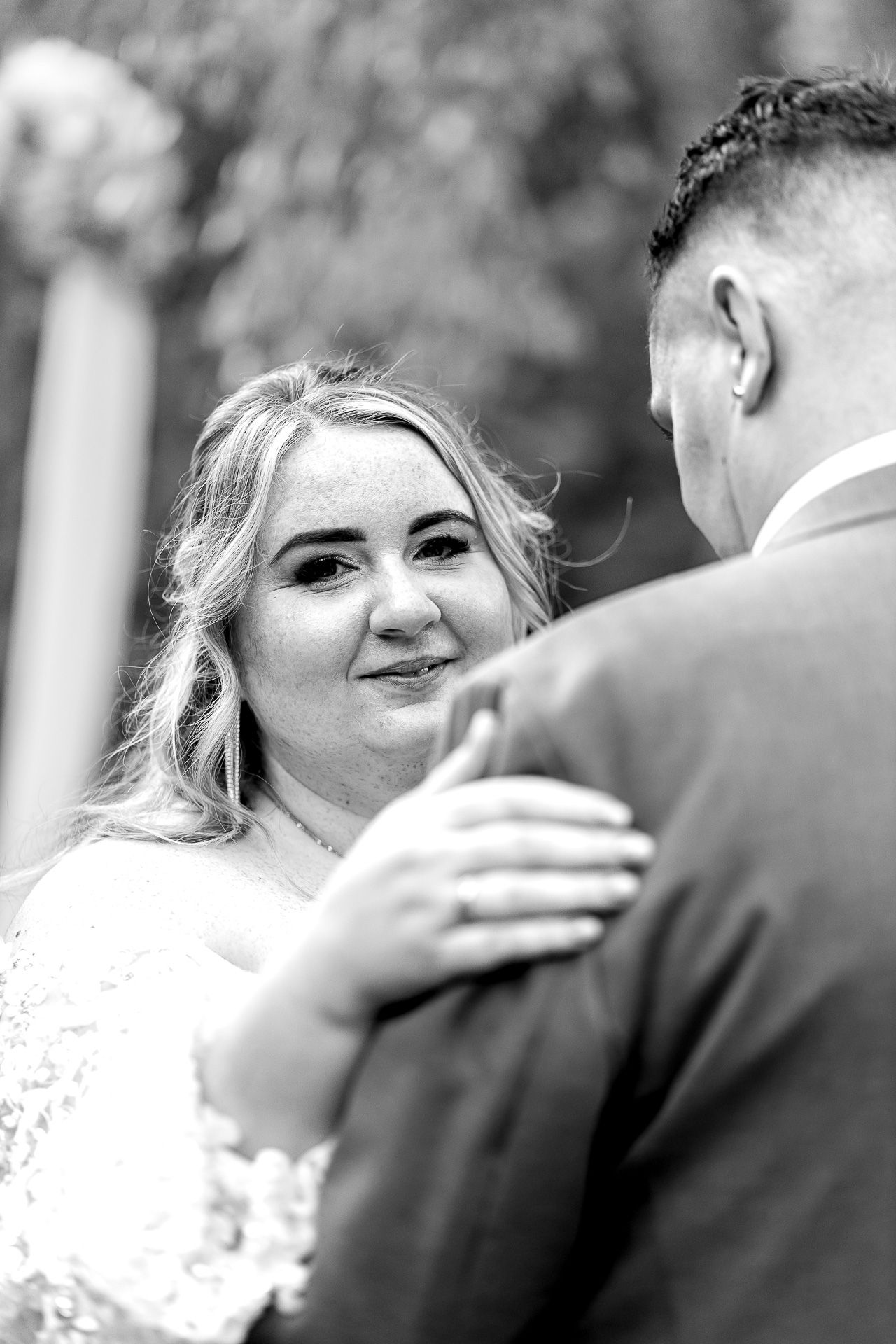 Black and white wedding photo series showing emotional first look moment between bride and groom outdoors.