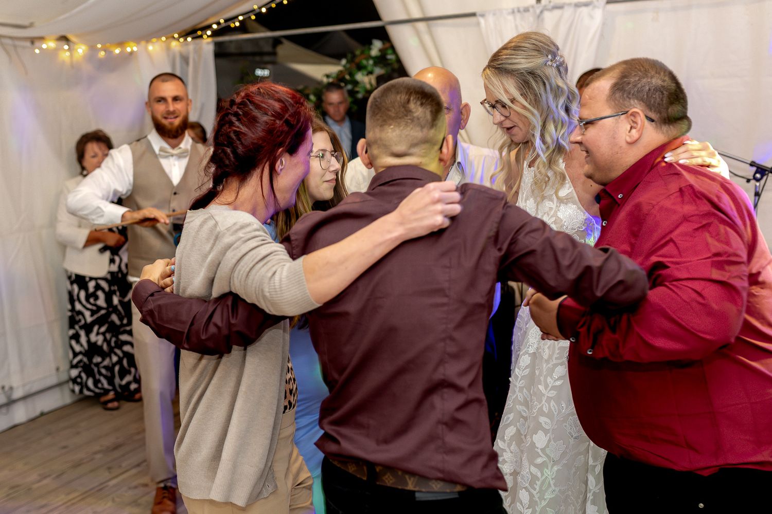 Couples dancing at a wedding reception in a decorated venue with burgundy and gray color scheme.